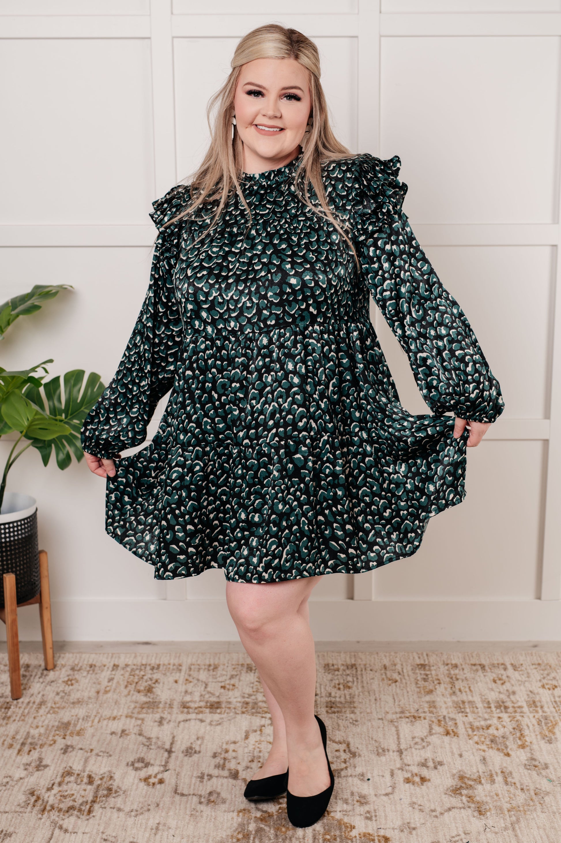 Green dotted poly satin dress with a ruffled mock neckline, long bubble sleeves with ruffle details, and a tiered skirt. Keyhole button closure and cased elastic sleeve cuffs.