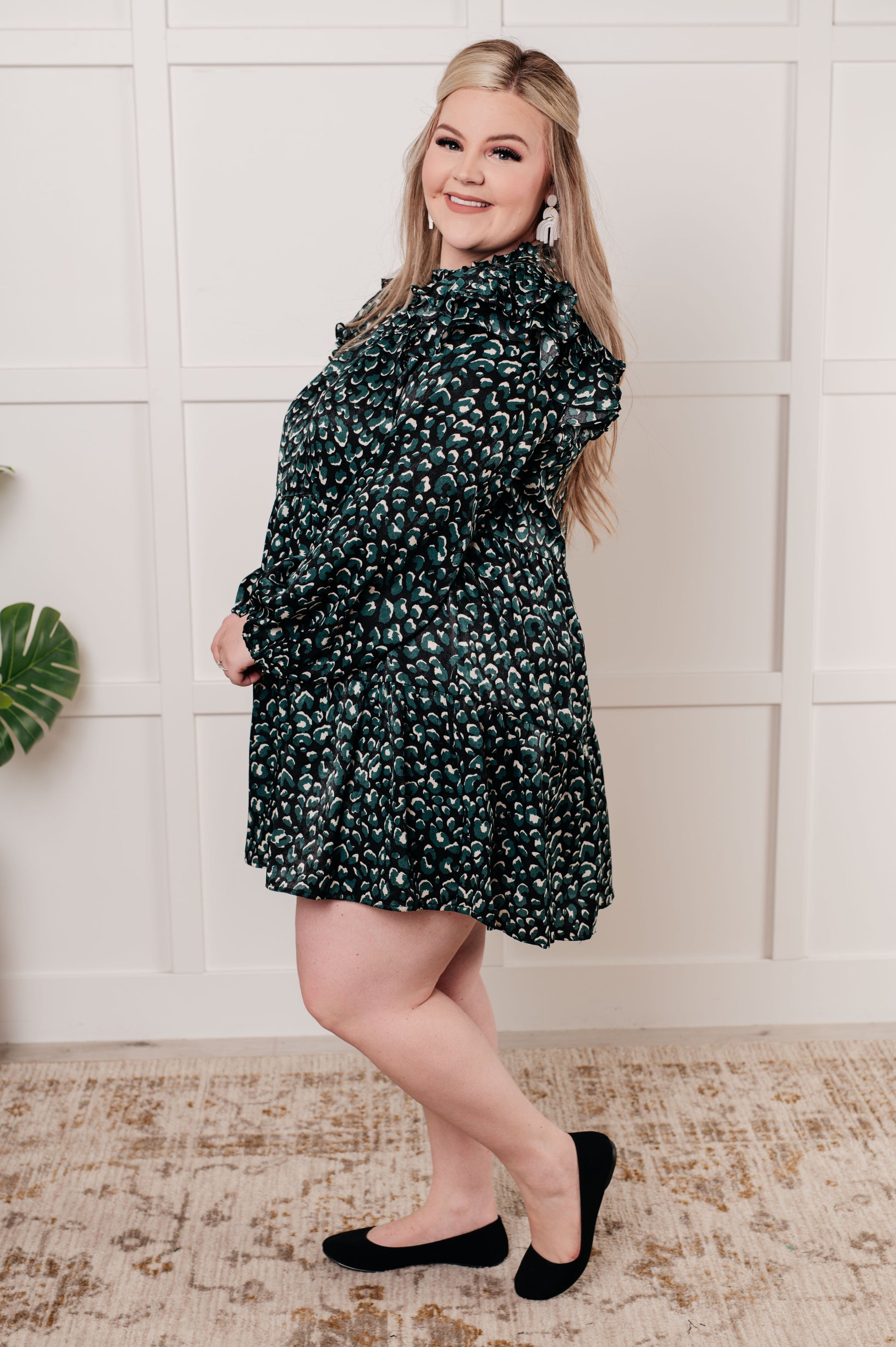 Green dotted poly satin dress with a ruffled mock neckline, long bubble sleeves with ruffle details, and a tiered skirt. Keyhole button closure and cased elastic sleeve cuffs.