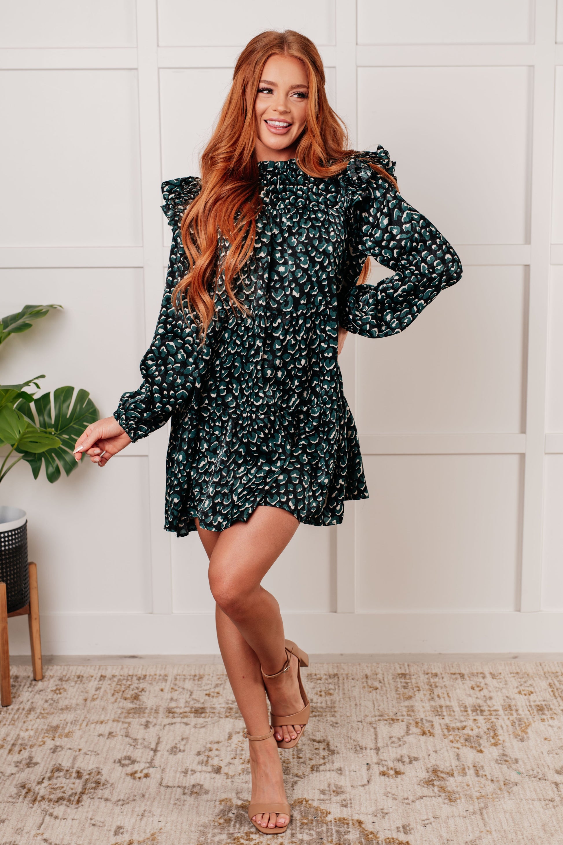 Green dotted poly satin dress with a ruffled mock neckline, long bubble sleeves with ruffle details, and a tiered skirt. Keyhole button closure and cased elastic sleeve cuffs.