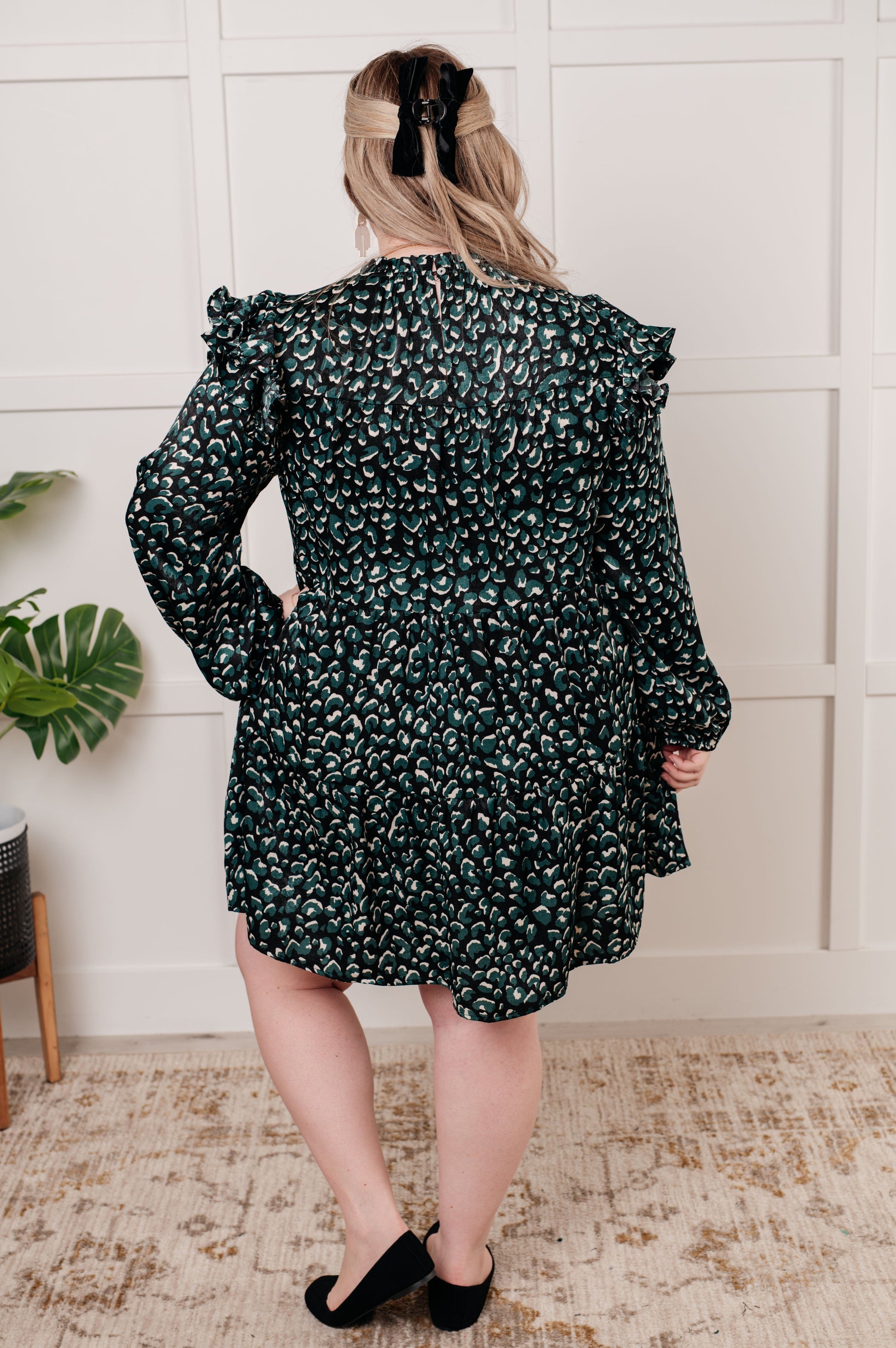 Green dotted poly satin dress with a ruffled mock neckline, long bubble sleeves with ruffle details, and a tiered skirt. Keyhole button closure and cased elastic sleeve cuffs.