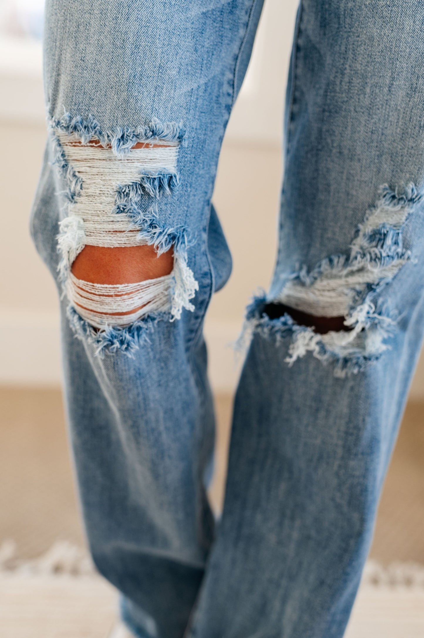 Light wash, high-rise, 90's straight jeans with distressed knees and chewed hems. 4-way stretch and zip fly.