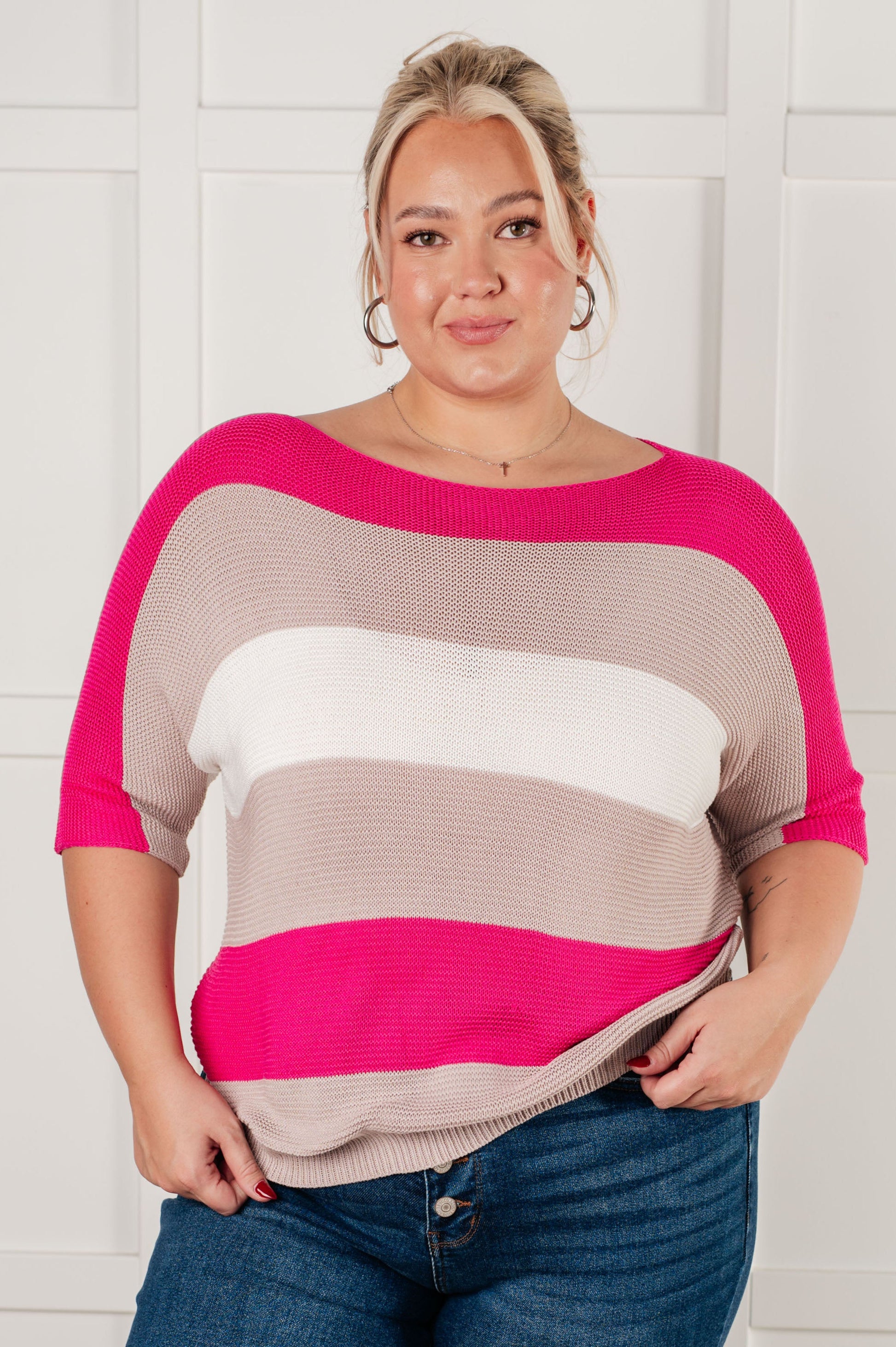 Women's Short Sleeve Knit Top in pink with a striped pattern, featuring a boat neckline, short dolman sleeves, and an exaggerated ribbed hemline. Made from mid-weight sweater knit fabric.