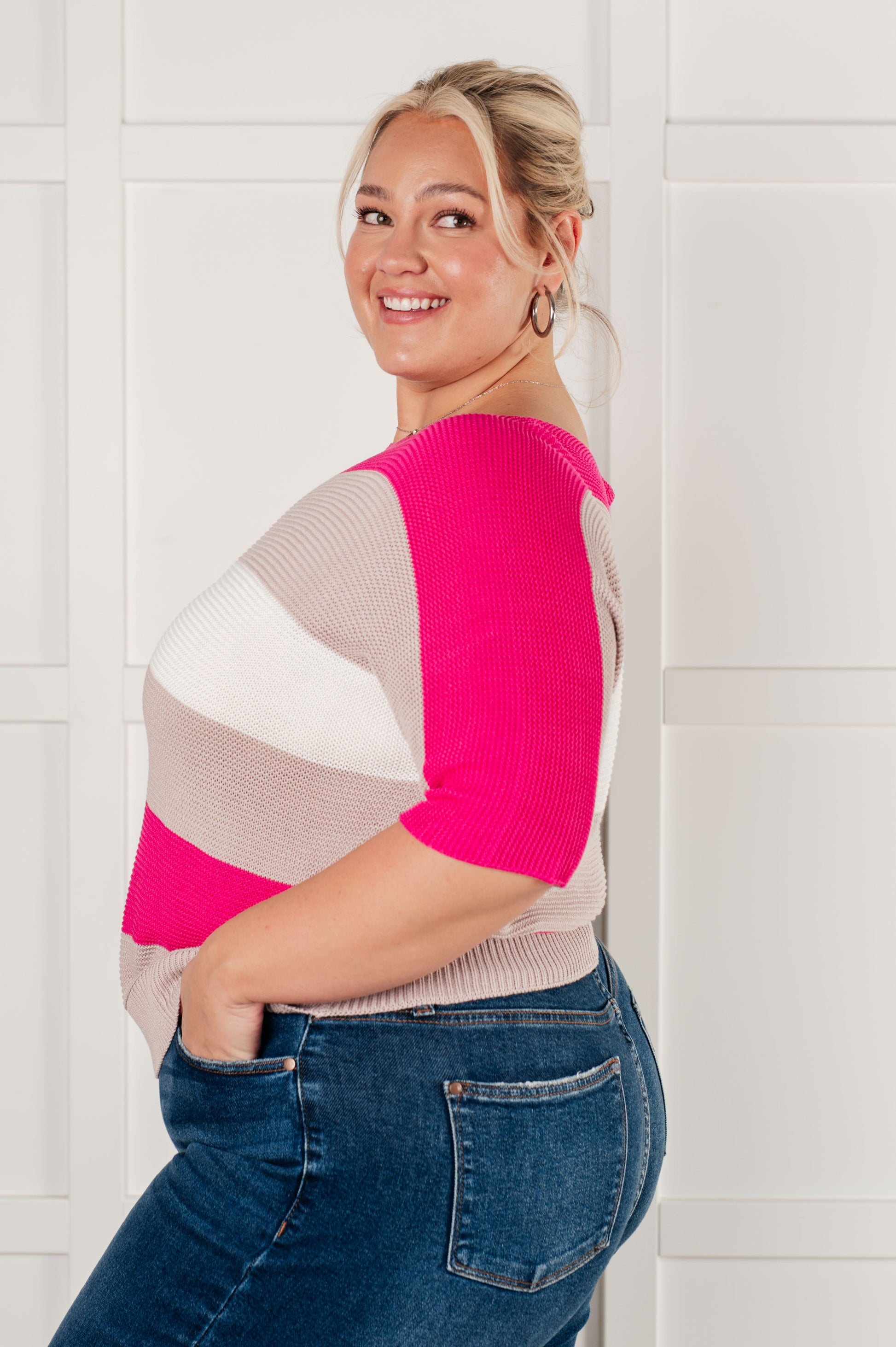 Women's Short Sleeve Knit Top in pink with a striped pattern, featuring a boat neckline, short dolman sleeves, and an exaggerated ribbed hemline. Made from mid-weight sweater knit fabric.