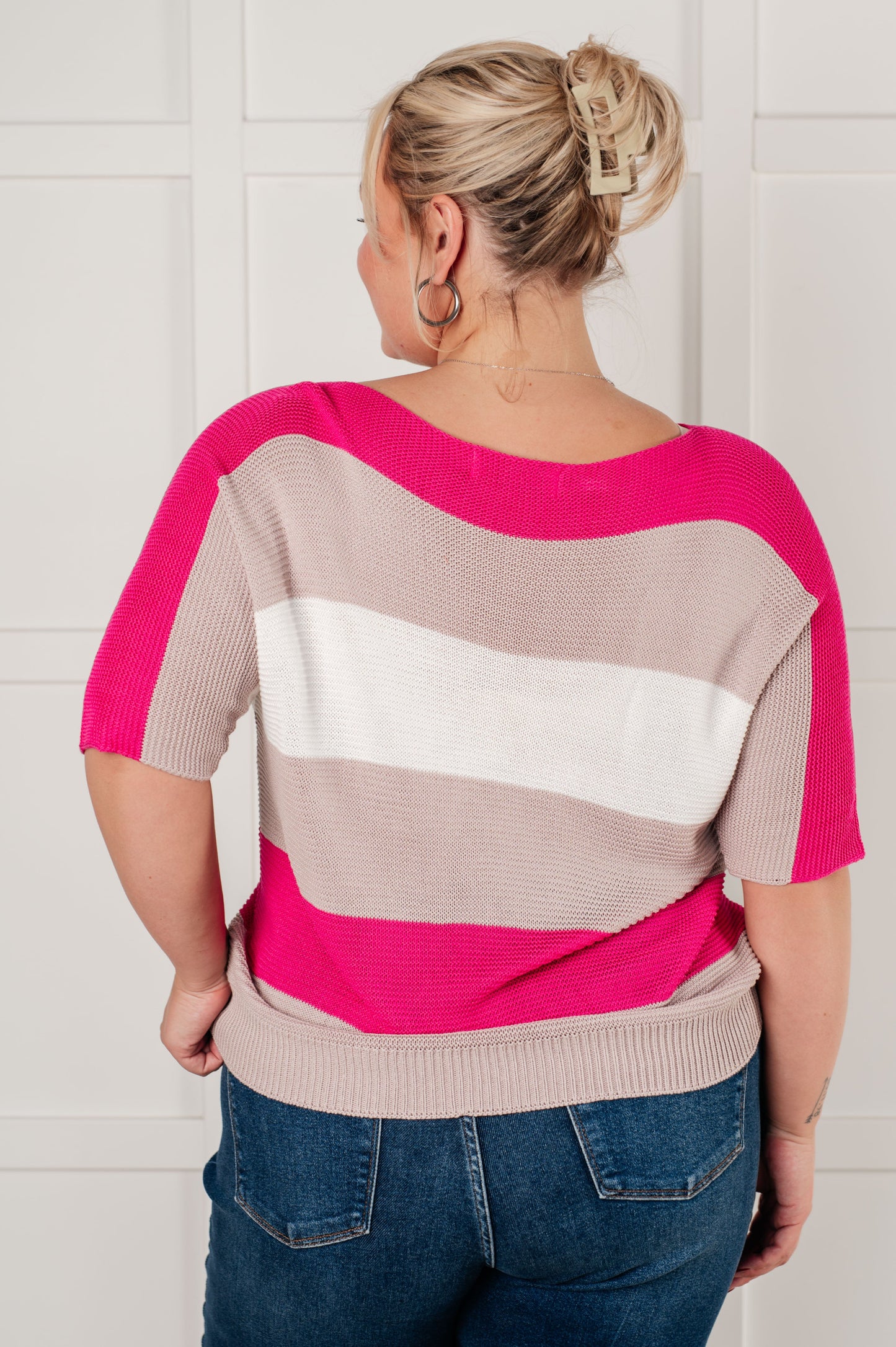 Women's Short Sleeve Knit Top in pink with a striped pattern, featuring a boat neckline, short dolman sleeves, and an exaggerated ribbed hemline. Made from mid-weight sweater knit fabric.