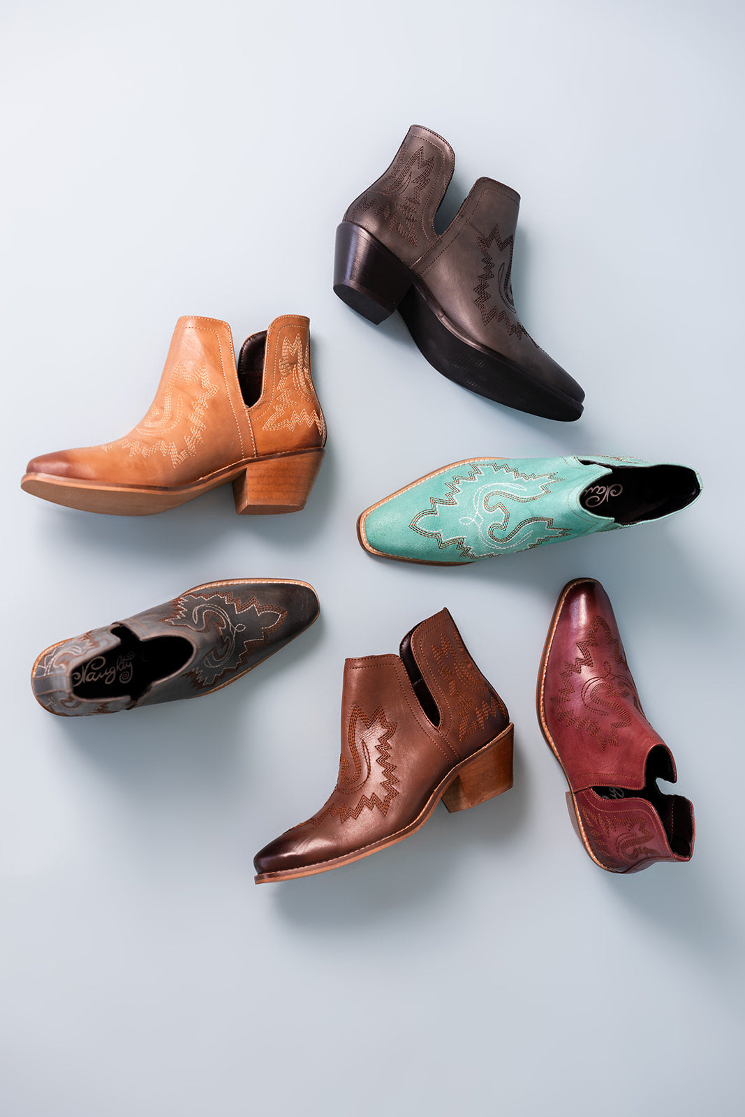 Leather booties with Western embroidery, roomy snip toe, cushioned footbed, and ankle slits in a variety of colors.