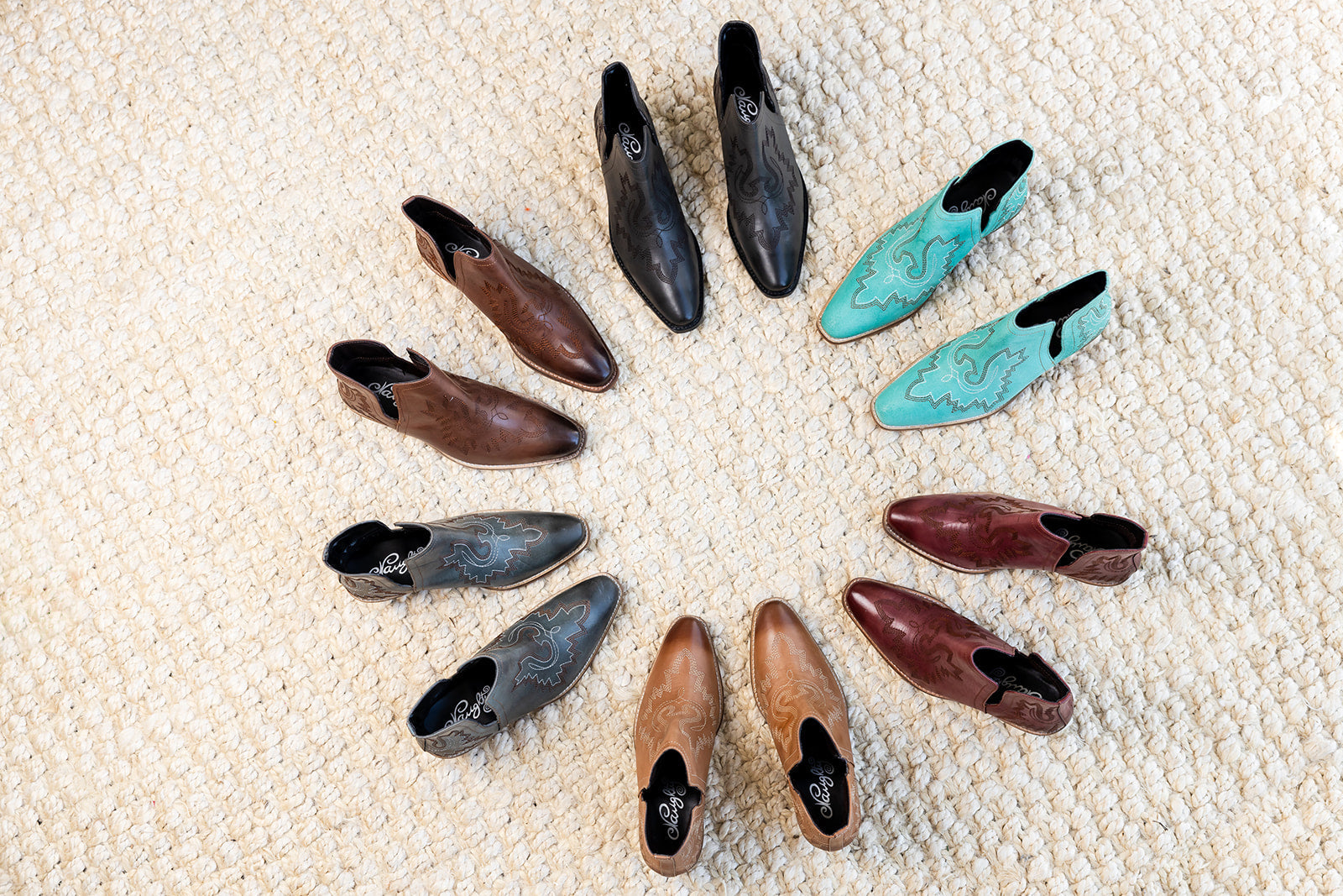 Leather booties with Western embroidery, roomy snip toe, cushioned footbed, and ankle slits in a variety of colors.