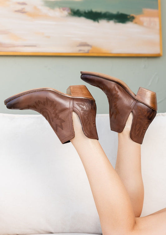 Brown leather booties with Western embroidery, roomy snip toe, cushioned footbed, and ankle slits.