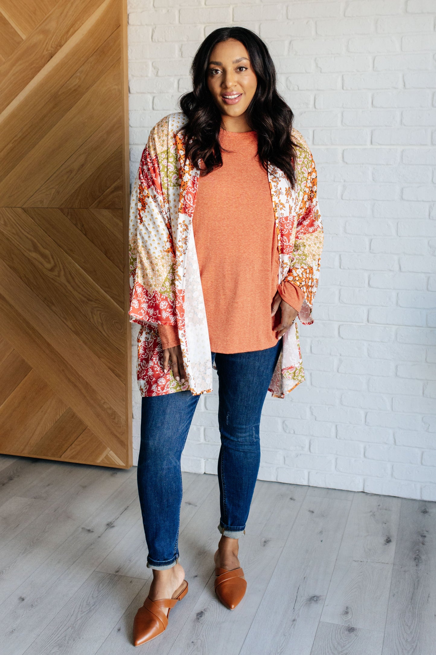 Pumpkin-colored long sleeve top with raglan sleeves, exposed seams, thumb hole cuffs, and scooped hemline.