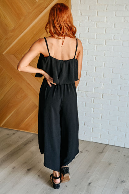 Back view of chic black jumpsuit outfit idea with tiered bodice design