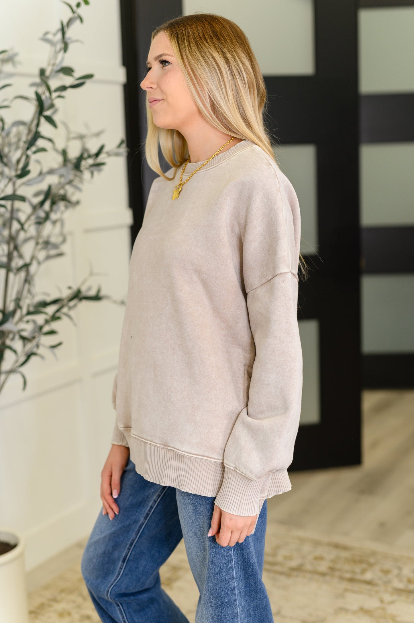 Side angle Safina Pullover in ash mocha fleece showing stepped hemline and ribbed cuff details.