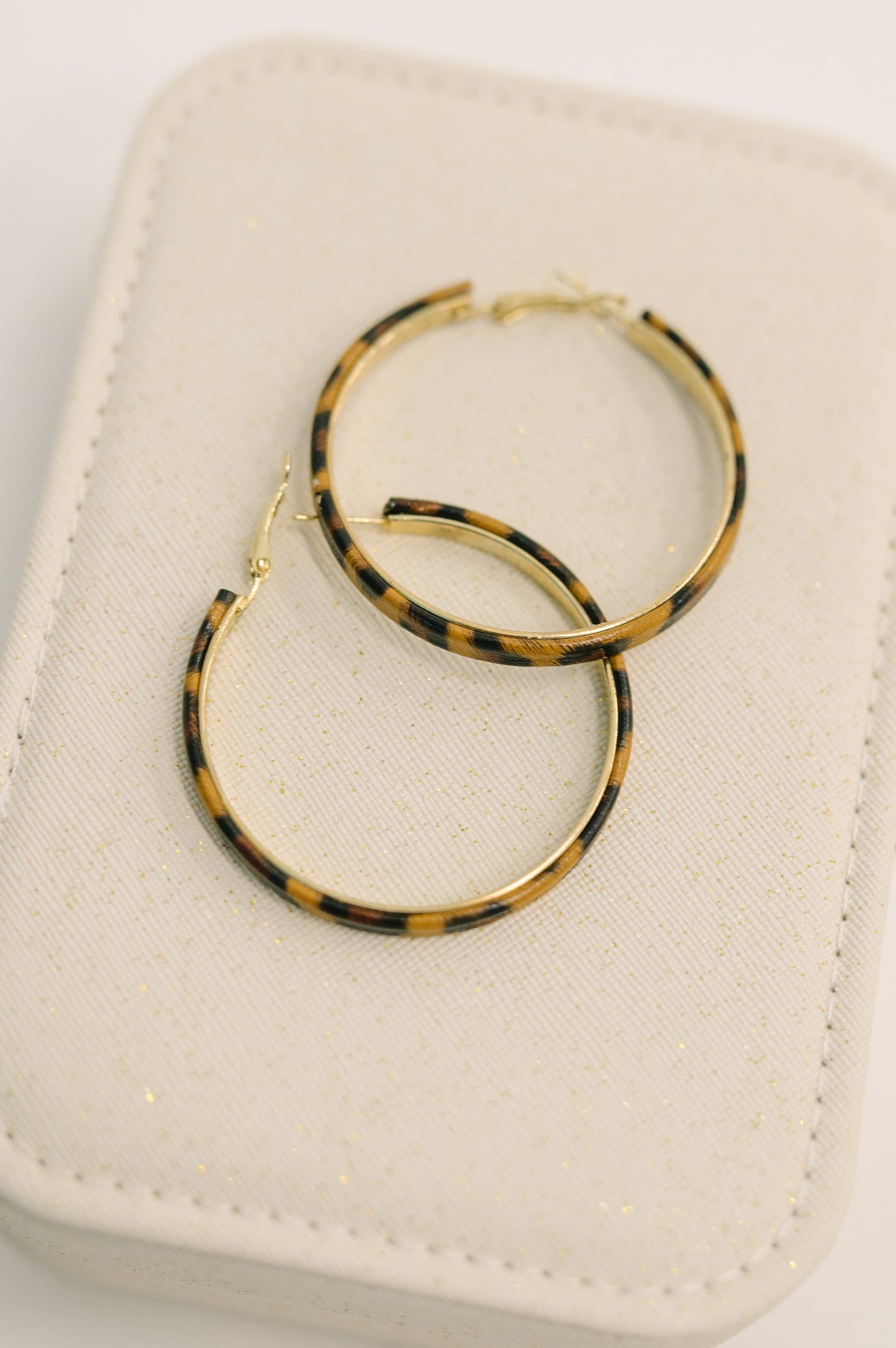 Front view of Sassy Assist Leopard Print Hoop Earrings showing leopard pattern detail.