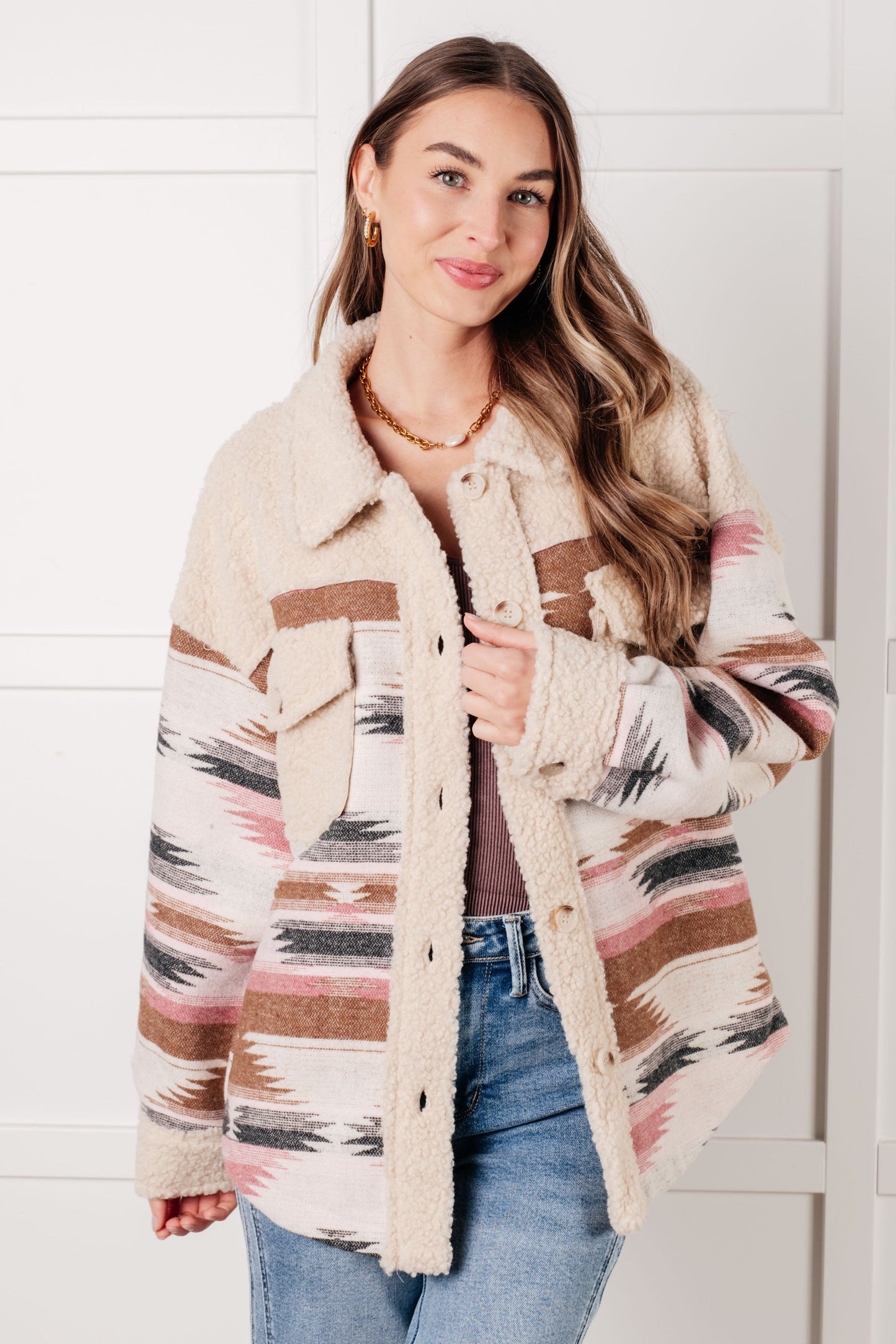 Model wearing Sedona Sunset Shacket in beige multi Aztec print with sherpa fleece panel.