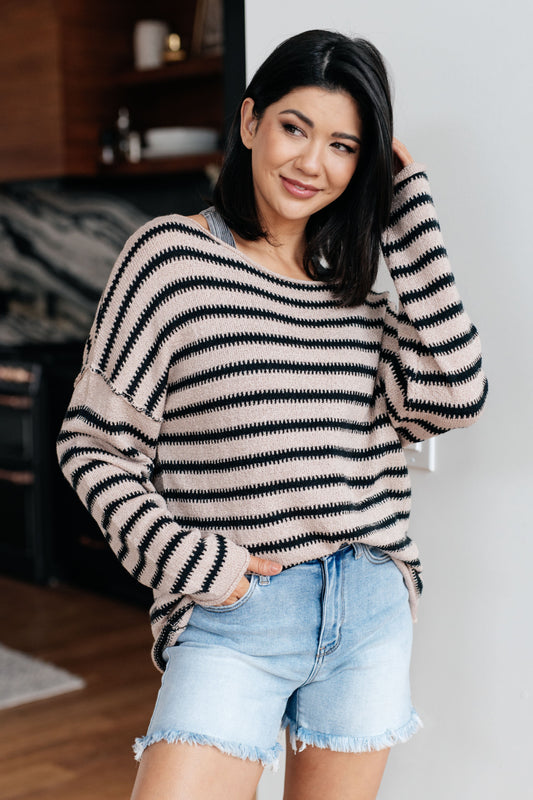 Model wearing Selma Striped Sweater in natural and black with boat neckline.