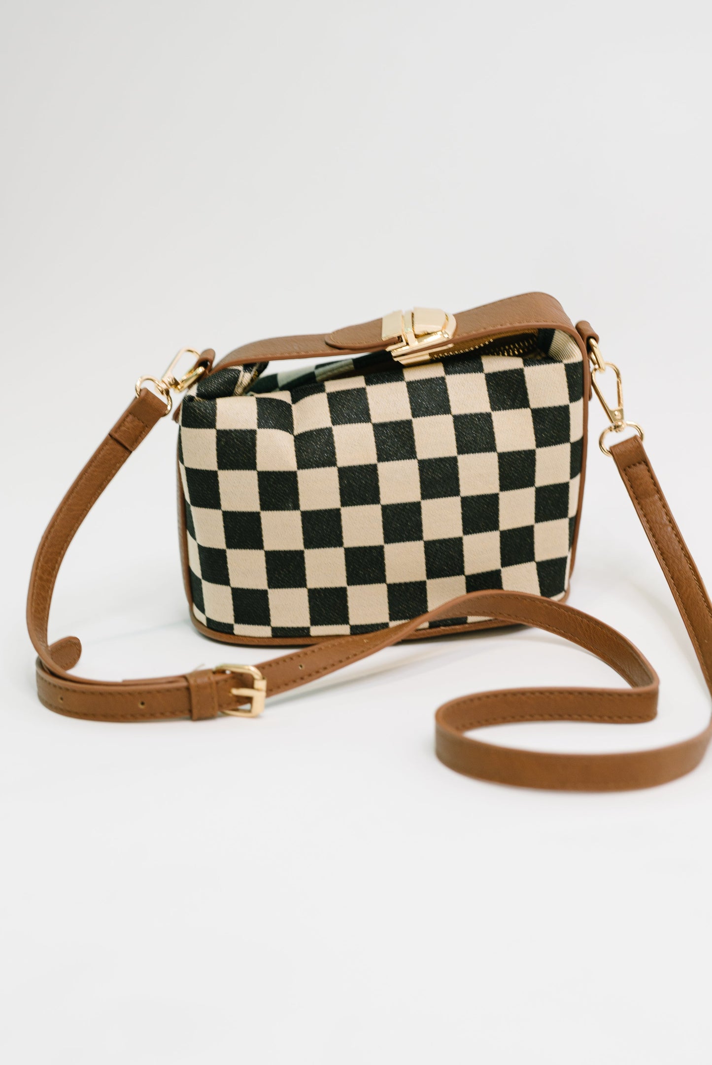 Front view of Send a Check Crossbody Bag showing checkered print and buckle closure.