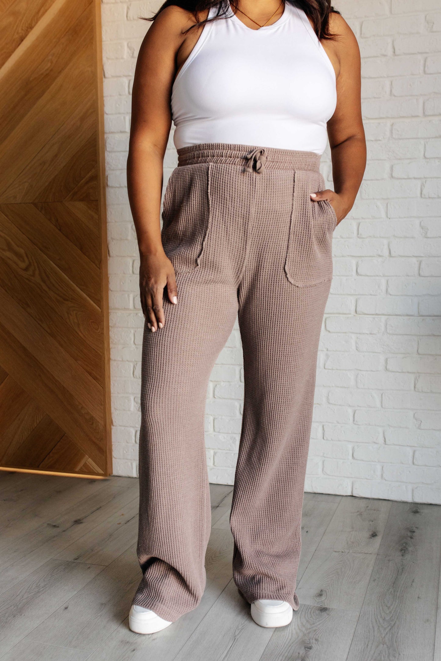 Mineral Wash Waffle Knit Pants in brown featuring a slightly wide leg silhouette, raw edge details, functional side patch pockets, and a cased elastic waistband with drawstring for a cozy, adjustable fit.