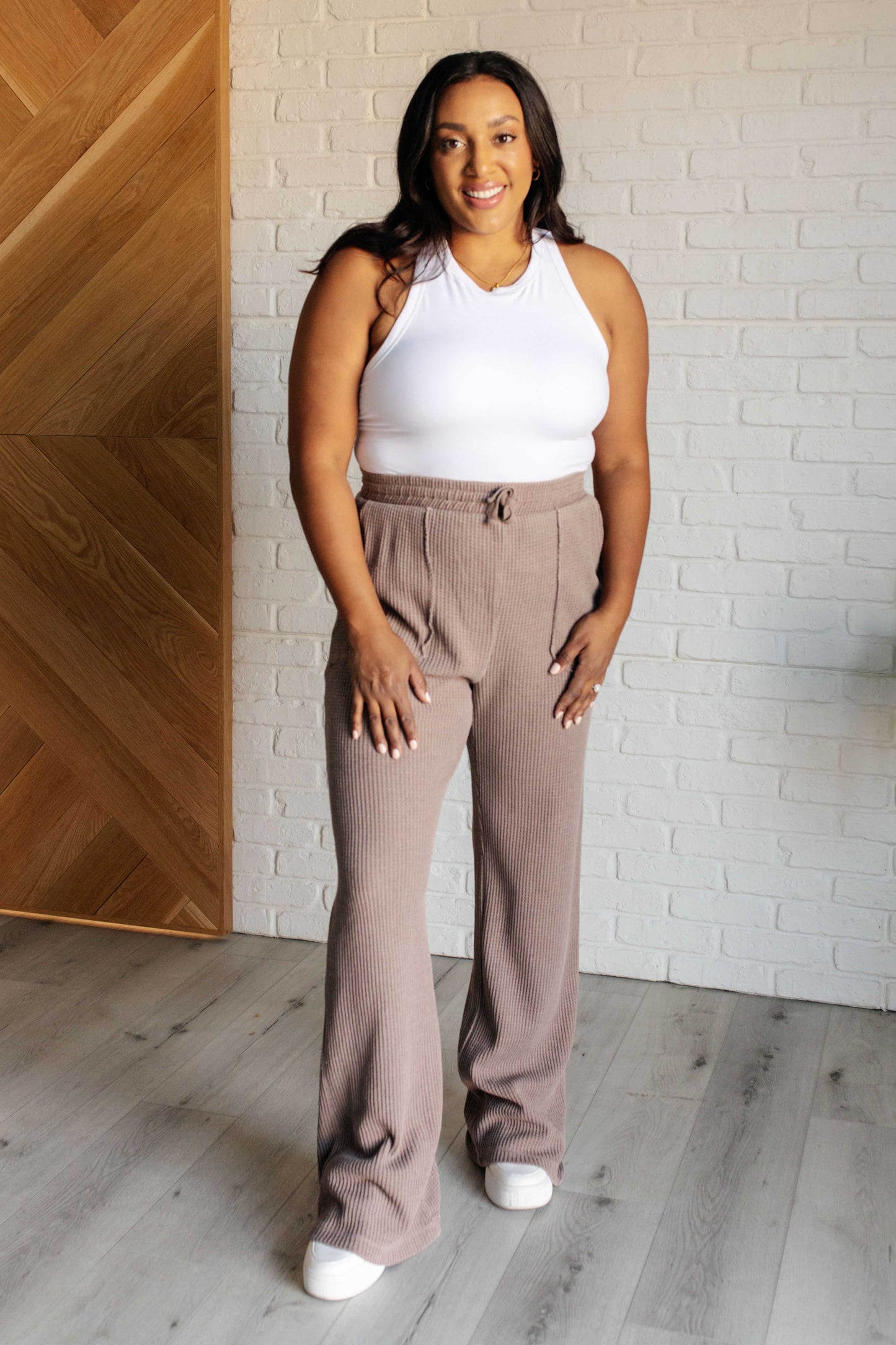 Mineral Wash Waffle Knit Pants in brown featuring a slightly wide leg silhouette, raw edge details, functional side patch pockets, and a cased elastic waistband with drawstring for a cozy, adjustable fit.