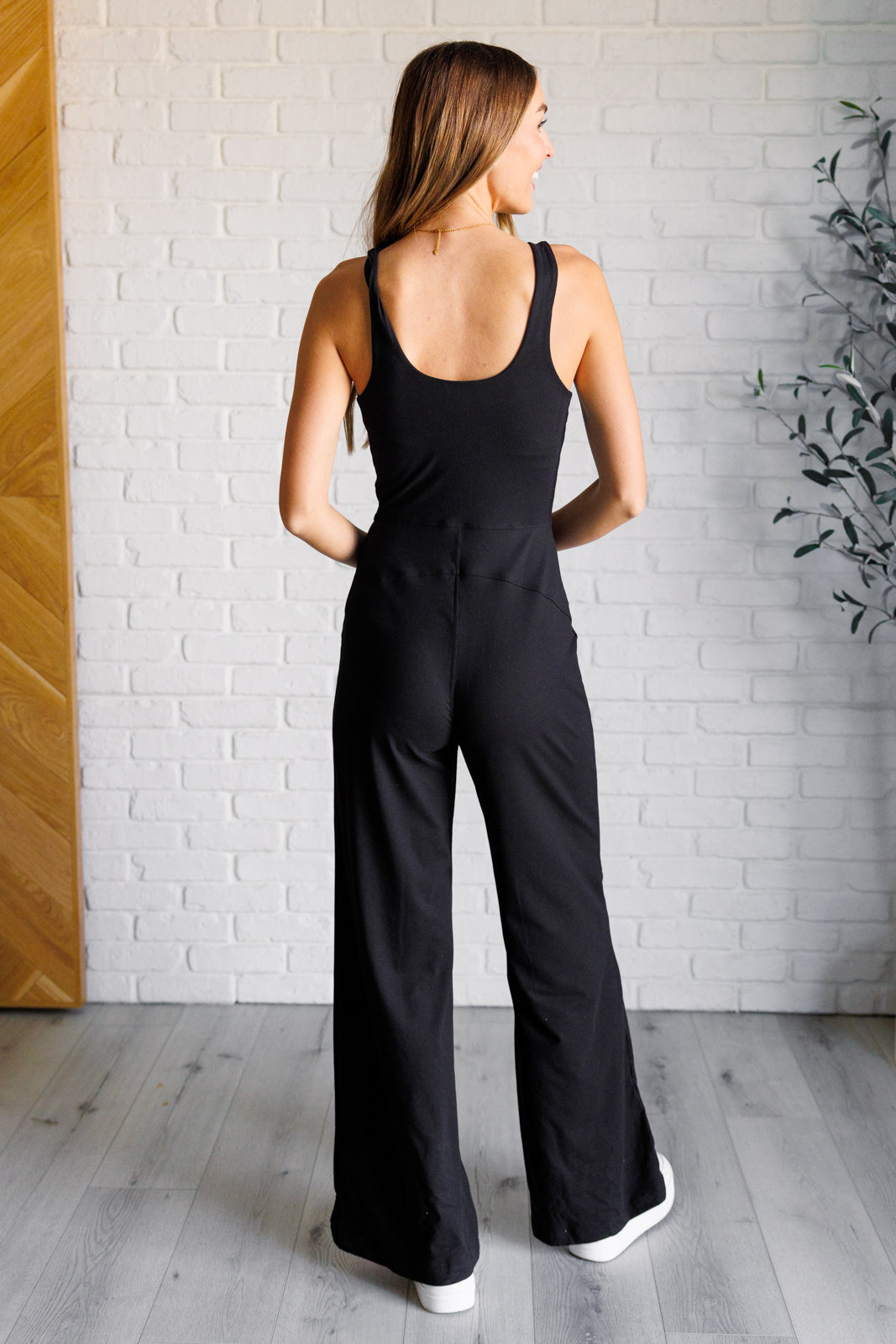 Black brushed microfiber onesie with a scoop neckline, slim fit top, relaxed straight bottom, and a built-in shelf bra with removable cups for support.