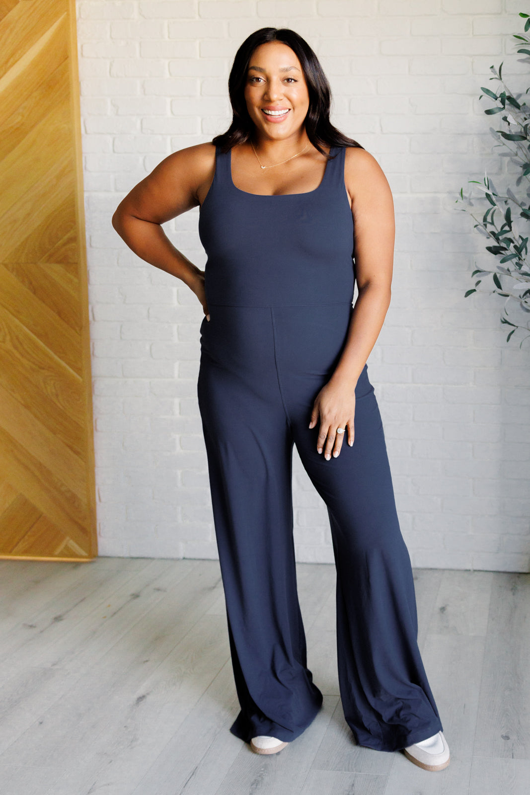 Navy brushed microfiber onesie with a scoop neckline, slim fit top, relaxed straight bottom, and a built-in shelf bra with removable cups for support.