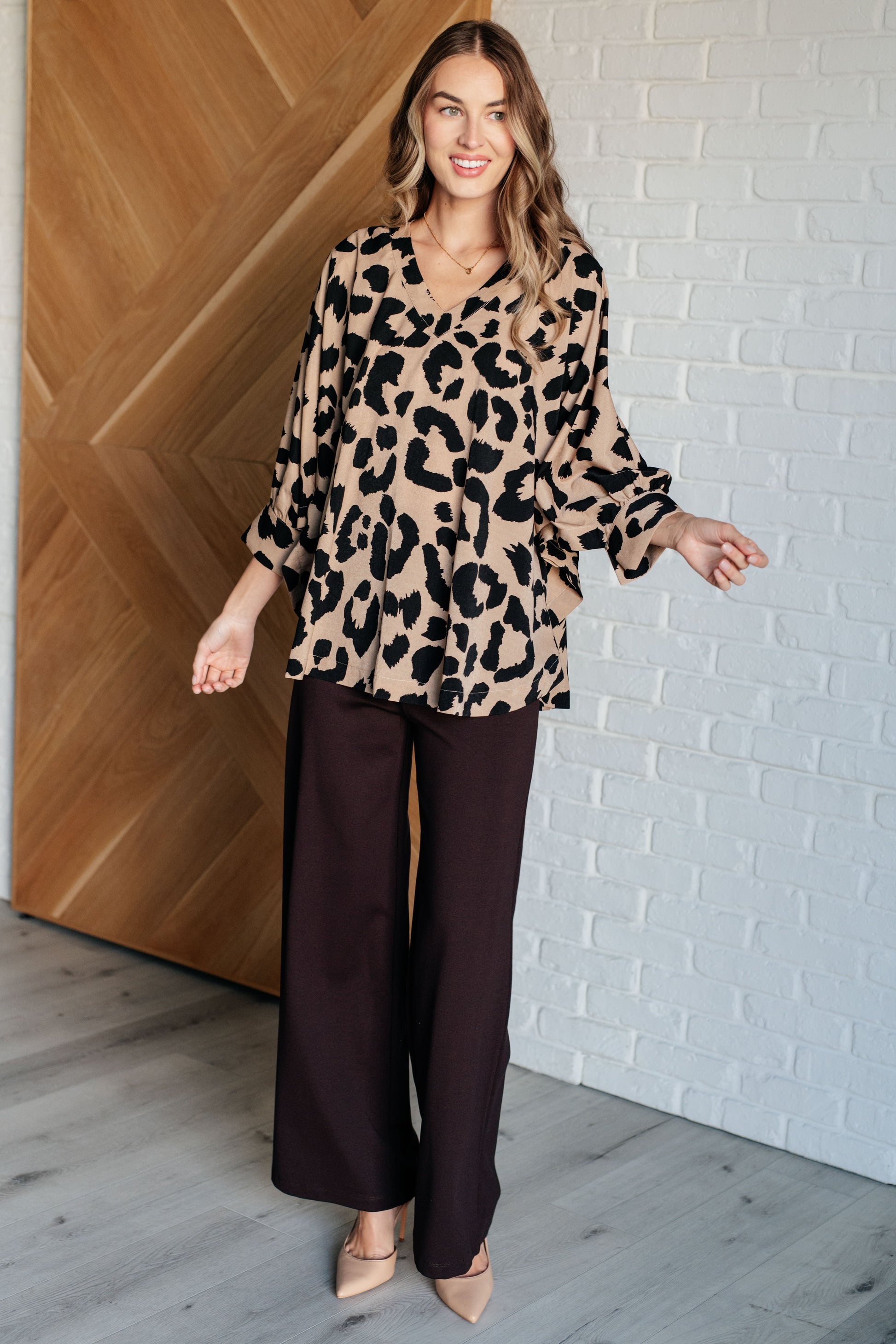 Beige and Black animal print blouse with a V-neckline, batwing sleeves, and a loose, flowing fit. Features banded cuffs with buttons.