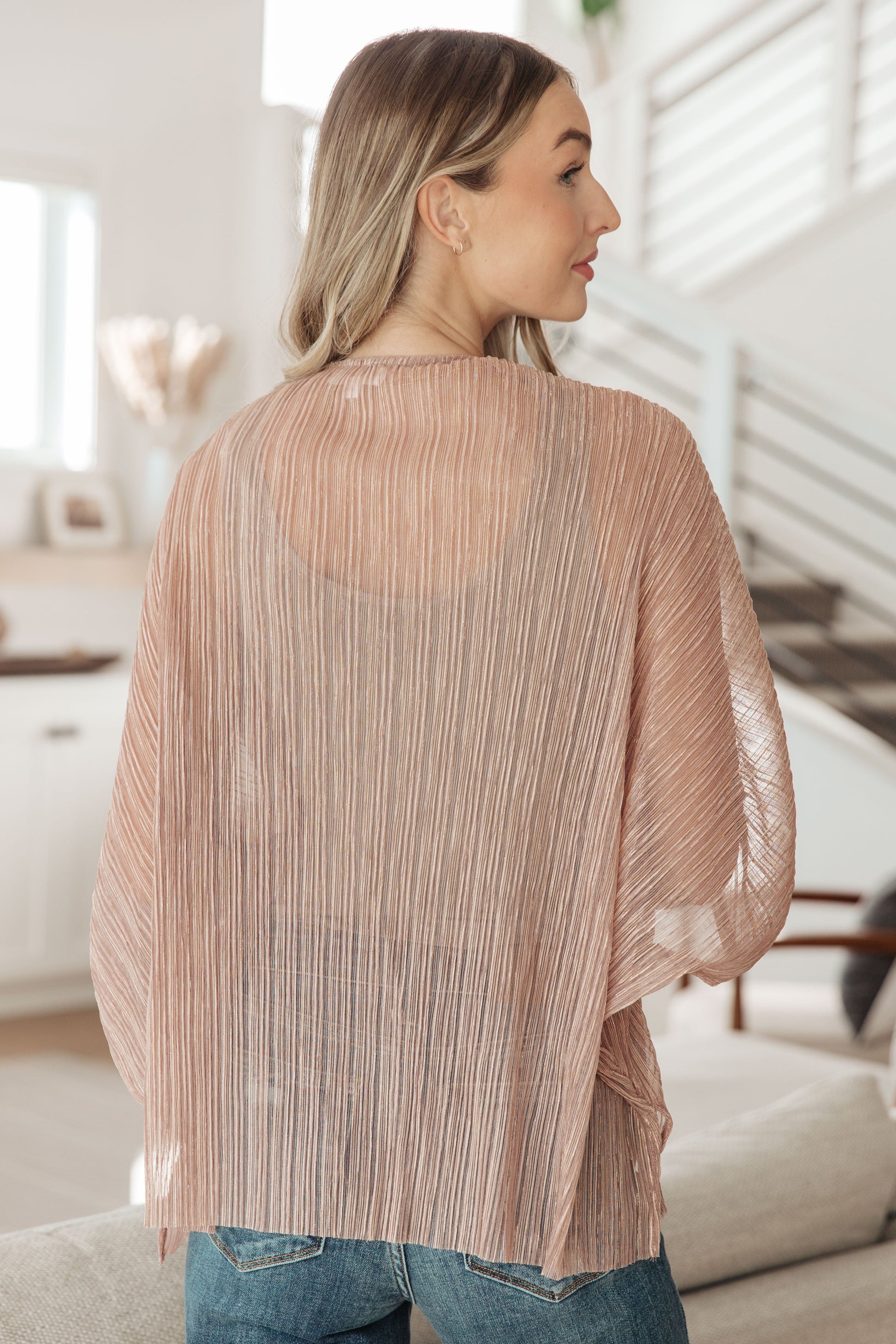 A lightweight kimono cardigan made from sheer lurex accordion pleat fabric in a soft beige color. It features an open front design with flowing half-length dolman sleeves, perfect for layering with stylish ensembles.