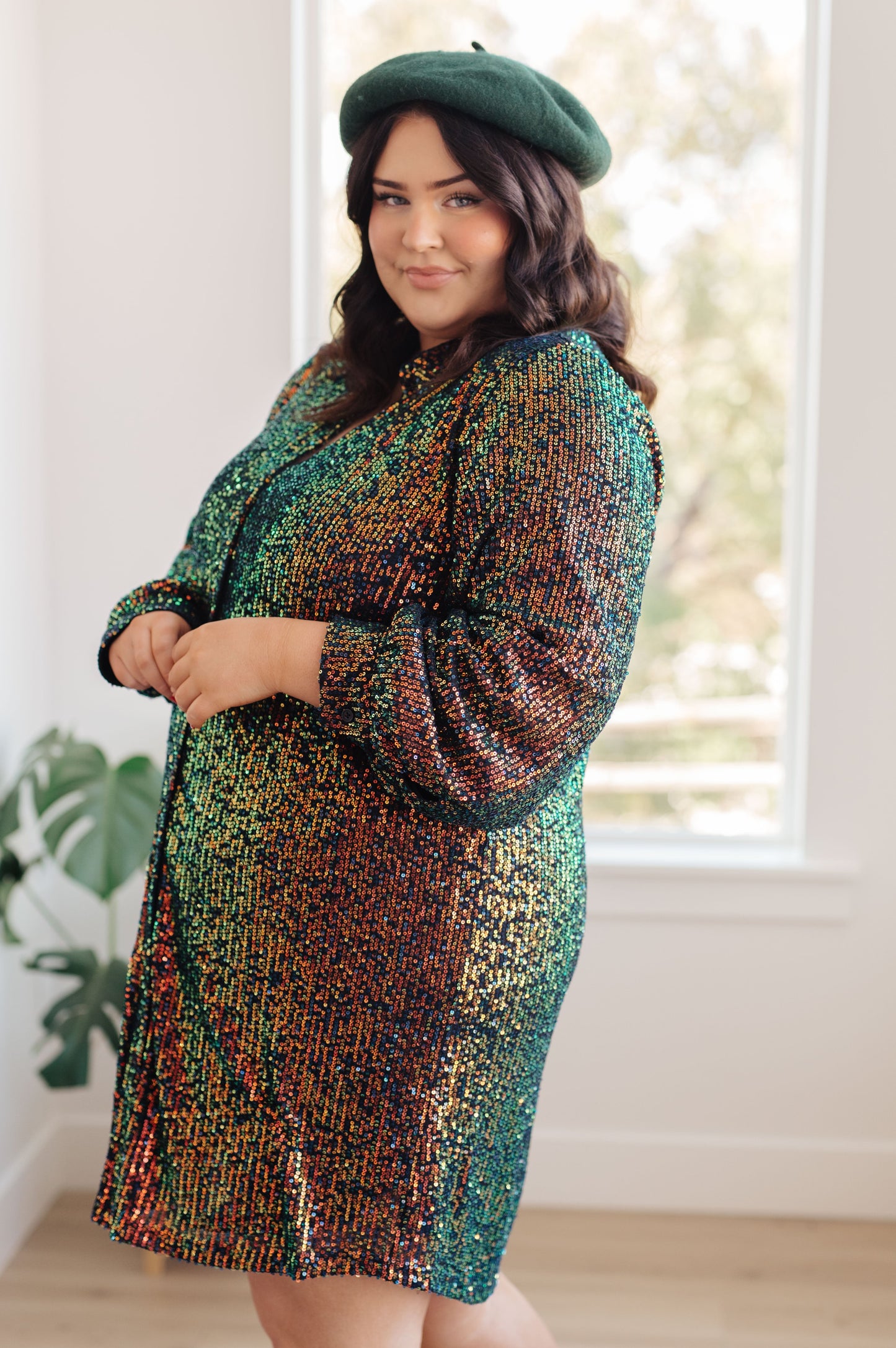 Black and green sequin mesh mini shirt dress with a collared neckline, long sleeves, and button front closure. Fully lined with buttoned cuffs.