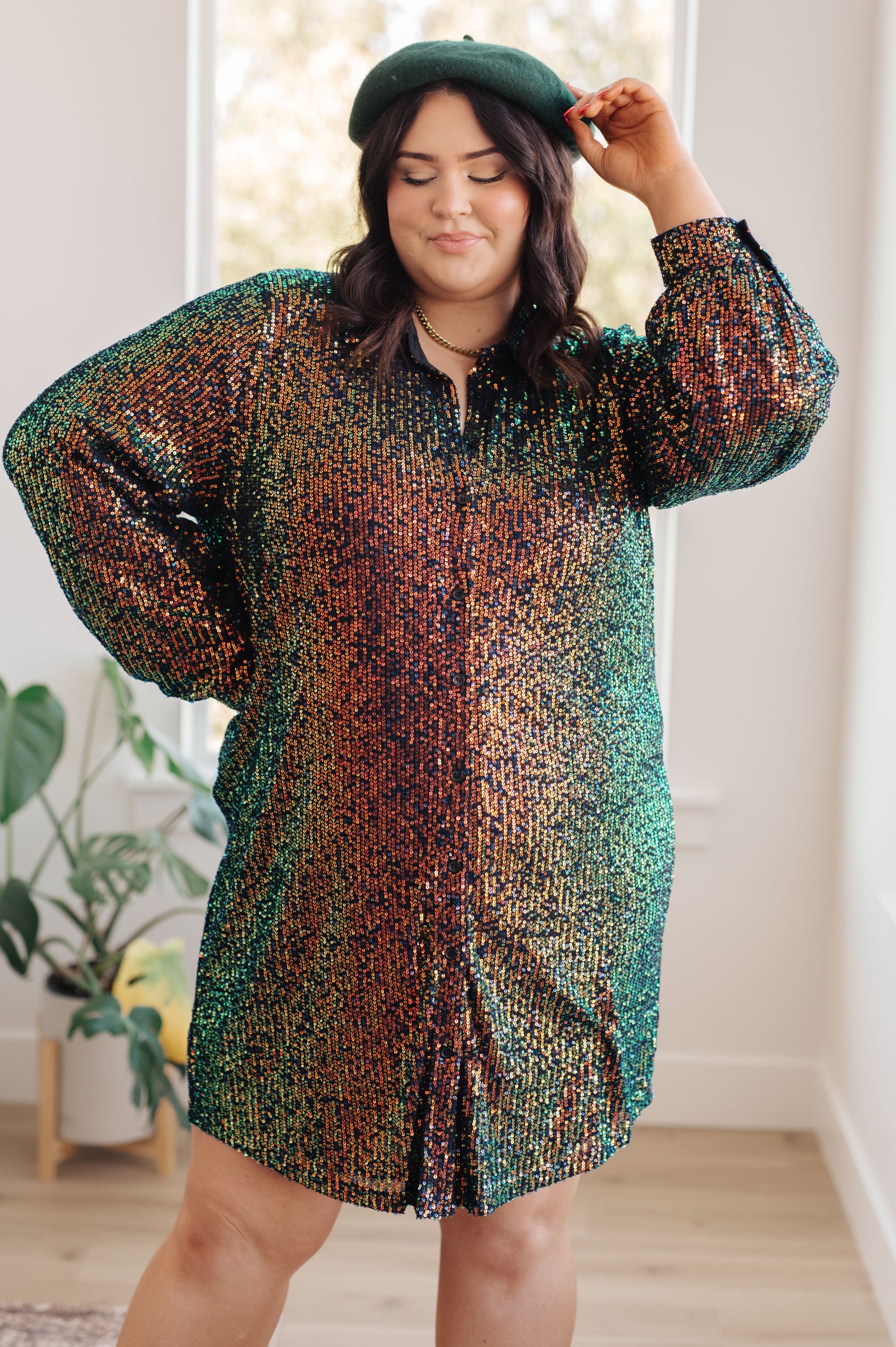 Black and green sequin mesh mini shirt dress with a collared neckline, long sleeves, and button front closure. Fully lined with buttoned cuffs.