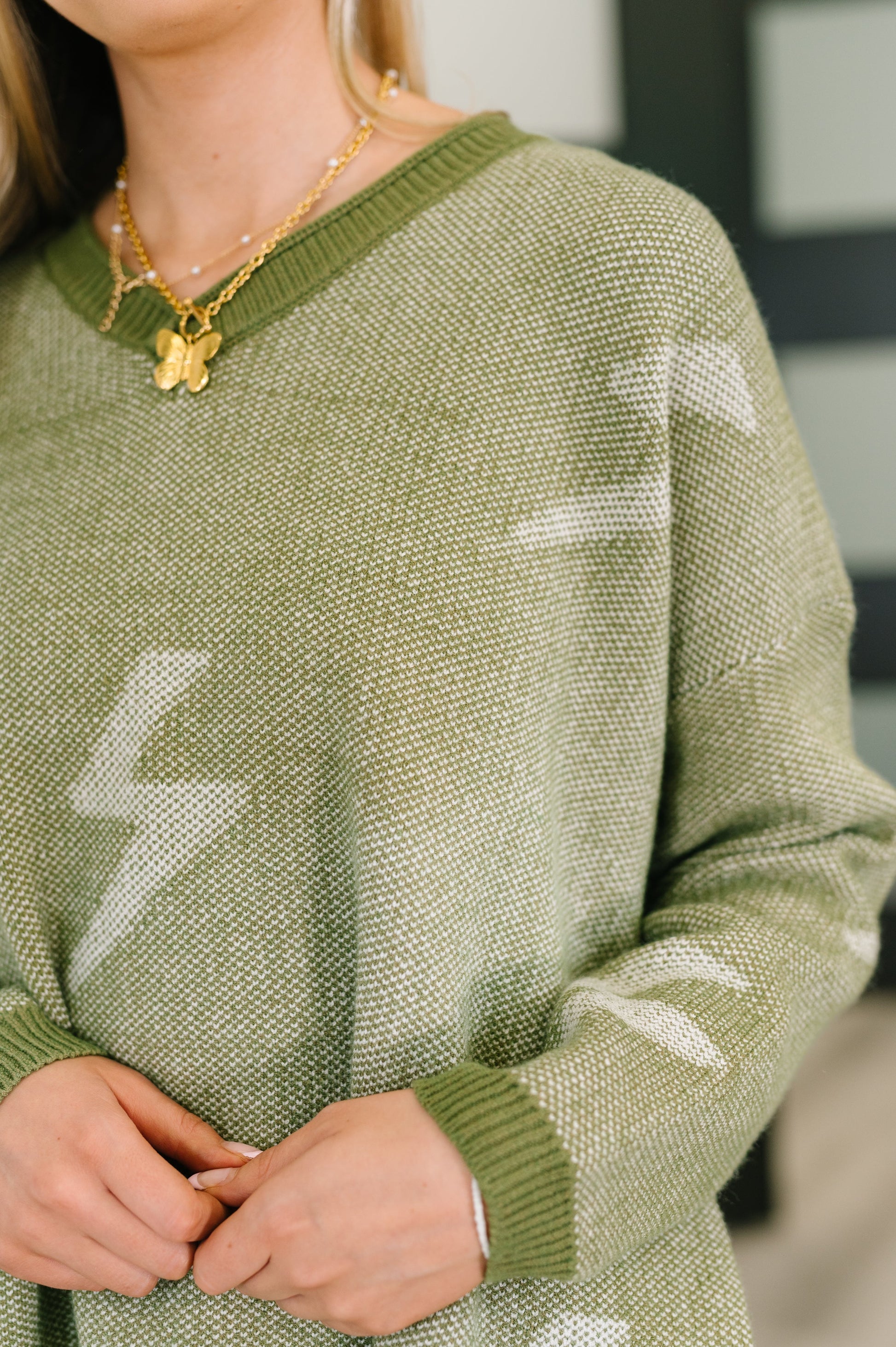 Close-up of Shoni V-Neck Sweater in Olive showing ribbed V-neck and soft knit texture.