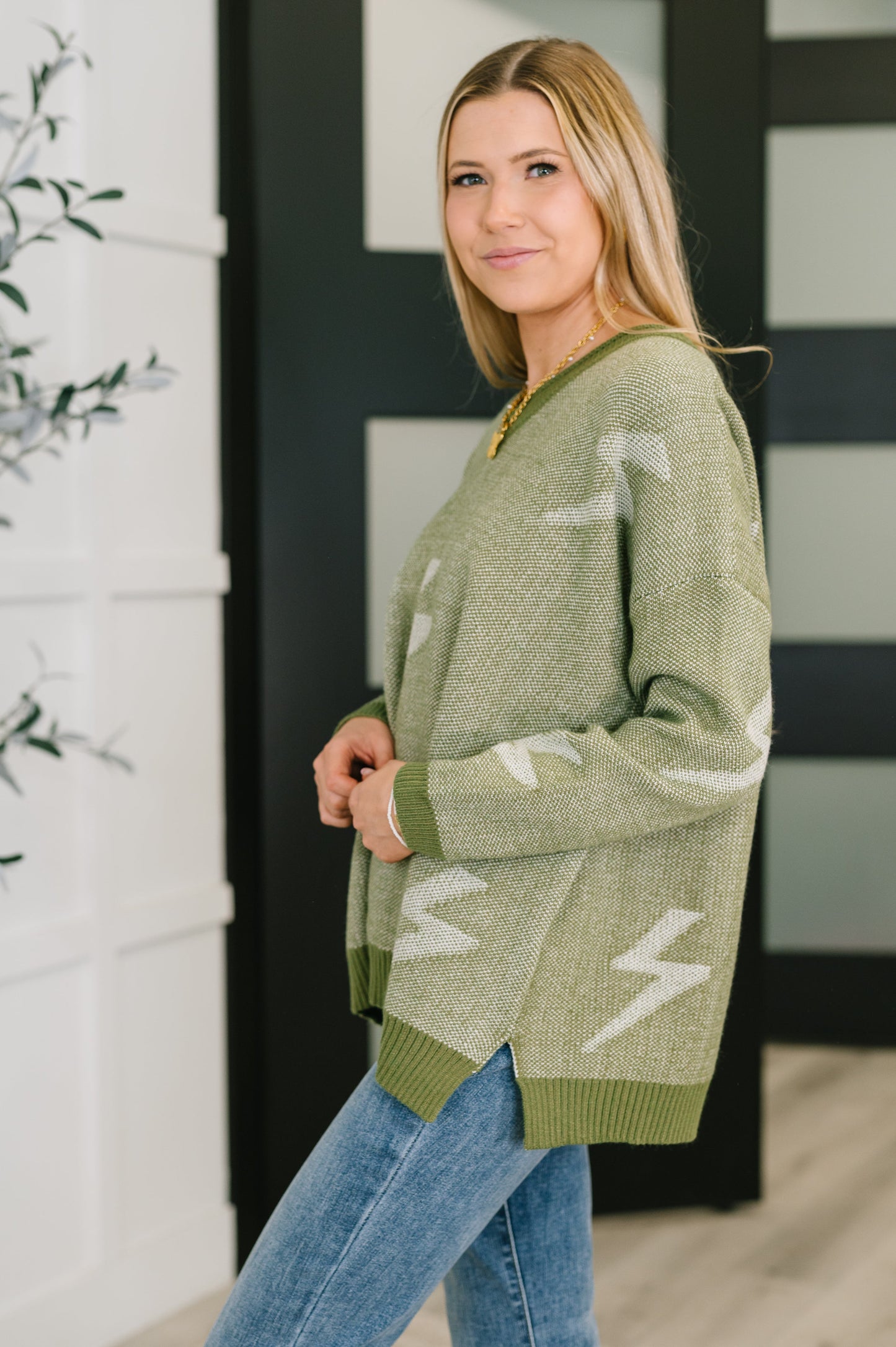 Side angle of Shoni V-Neck Sweater in Olive highlighting relaxed fit and mid-weight knit.