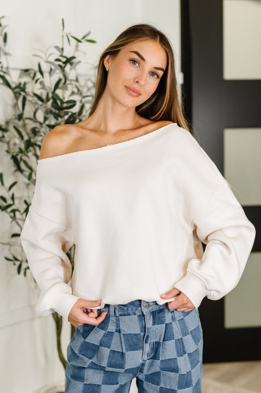 Front view of model wearing the Marlowe Off Shoulder Top in Bone with relaxed fit and raw neckline.