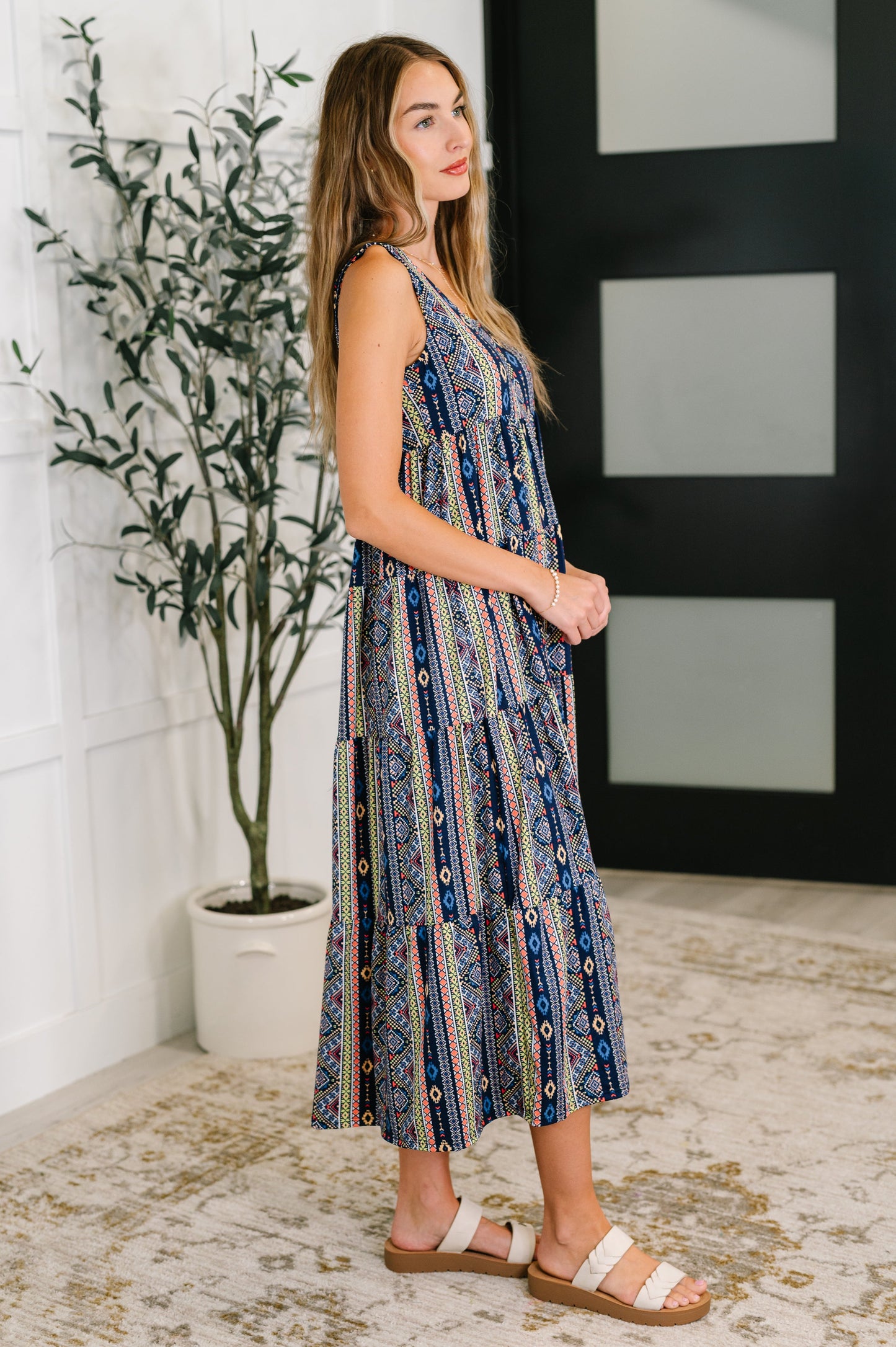 Side view of Sierra Gathered Tiered Dress in navy highlighting flowy tiered design and high-stretch knit fabric.