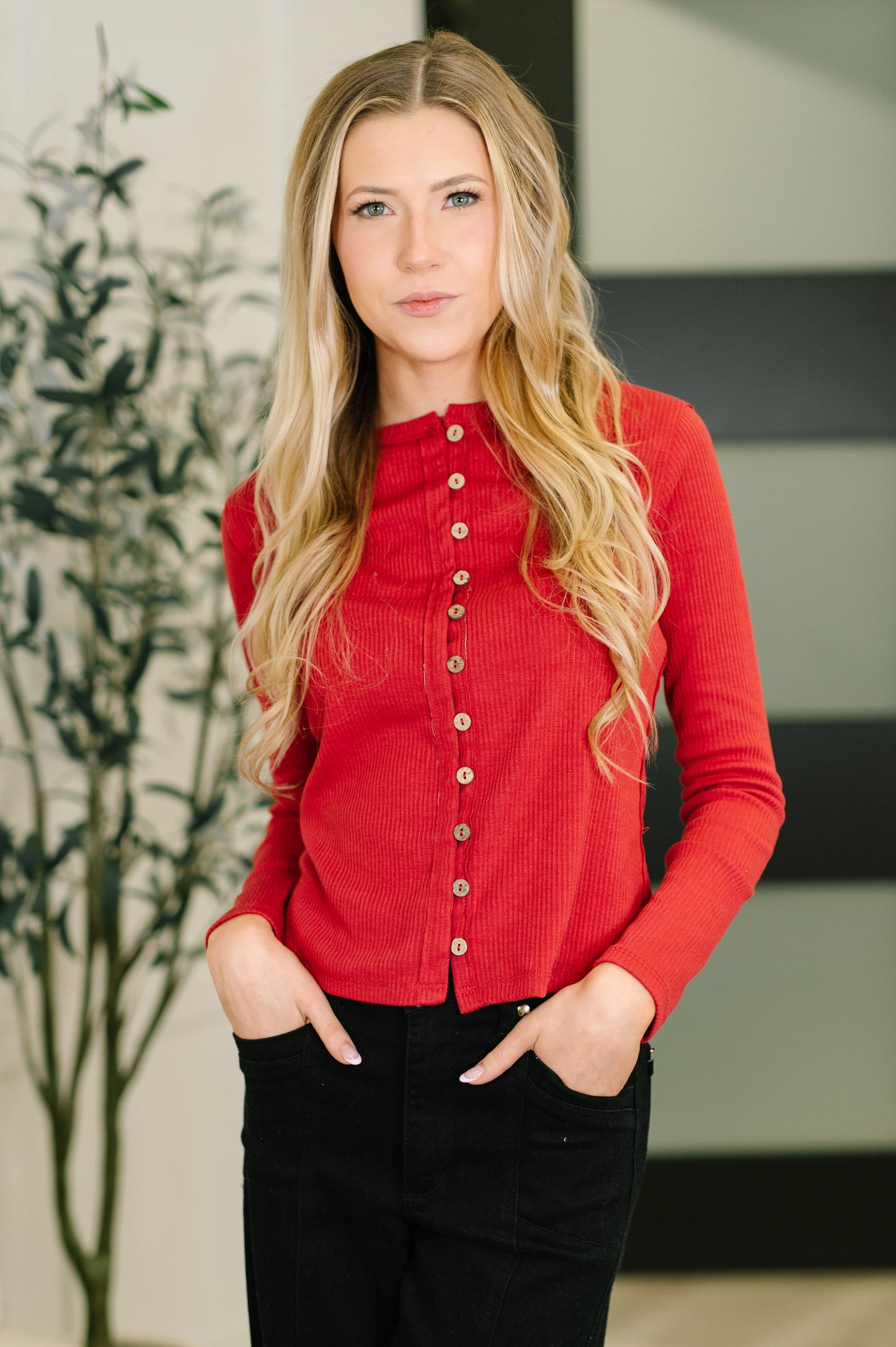 Model wearing Sigourney Button Down Cardigan in red ribbed knit with button front.