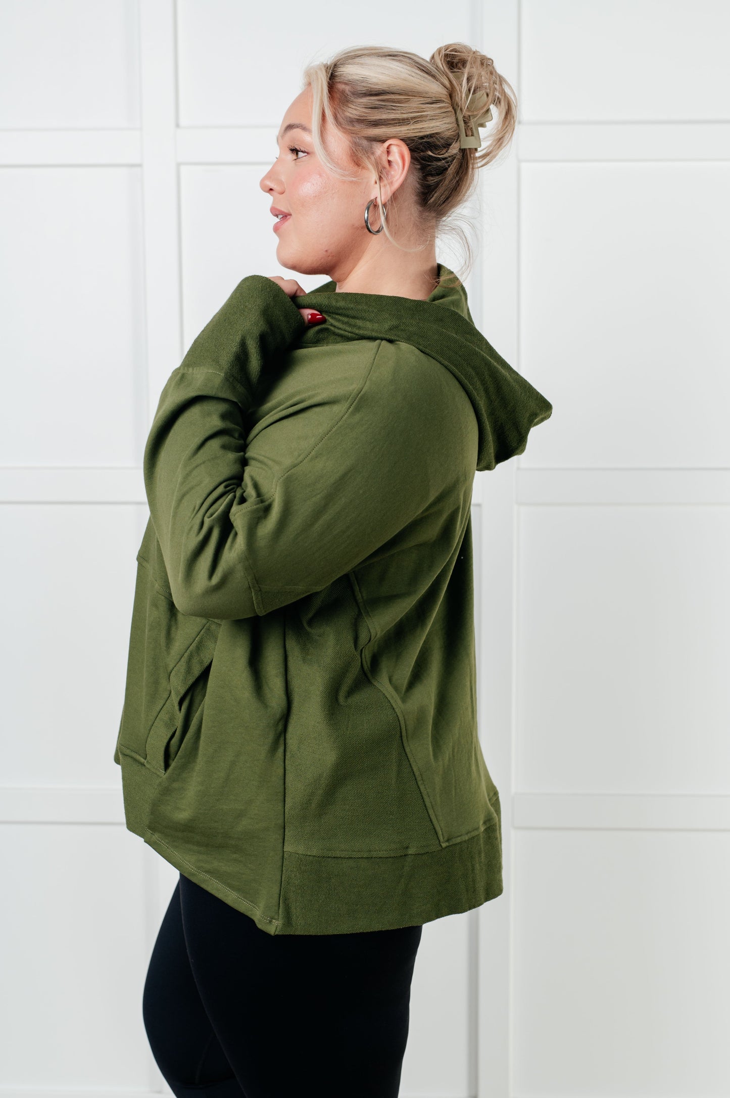 Women's green hooded pullover made with soft French Terry fabric, featuring snap button closures, long drop-shoulder sleeves with exaggerated cuffs, contrast details, and functional side pockets.