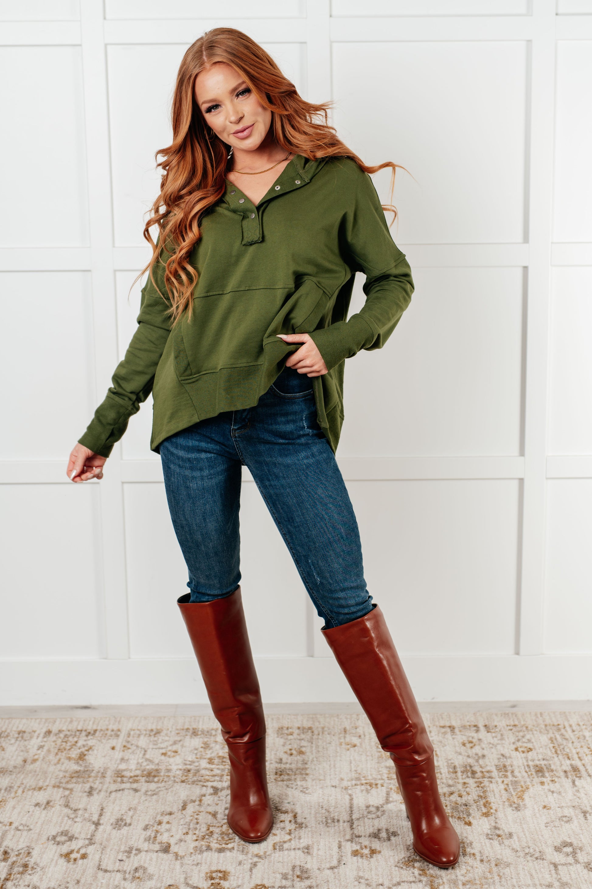 Women's green hooded pullover made with soft French Terry fabric, featuring snap button closures, long drop-shoulder sleeves with exaggerated cuffs, contrast details, and functional side pockets.