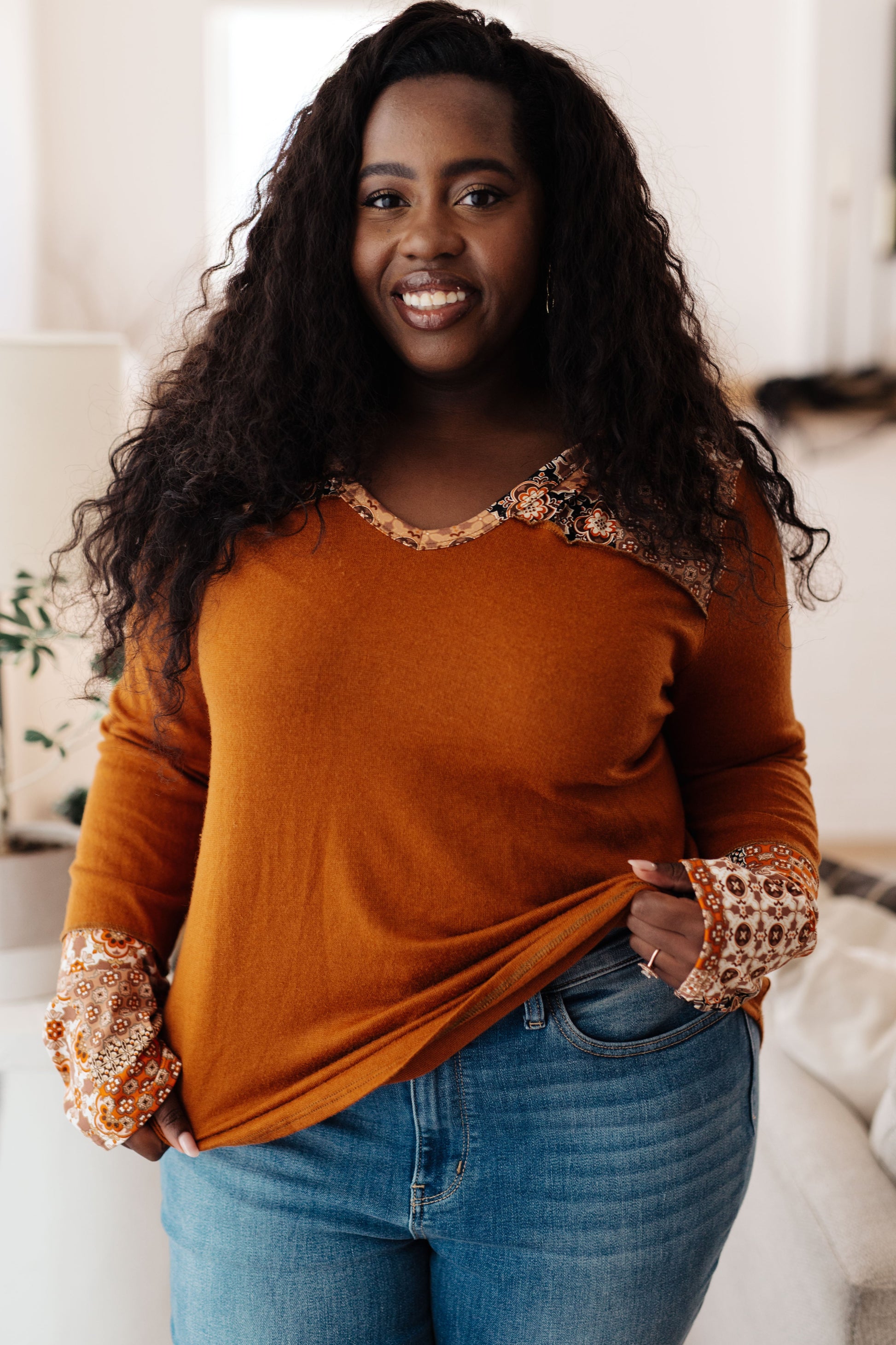 Plus-size model in Trissie Mixed Print Hoodie, rust brushed knit with patterned cuff and hood accents.