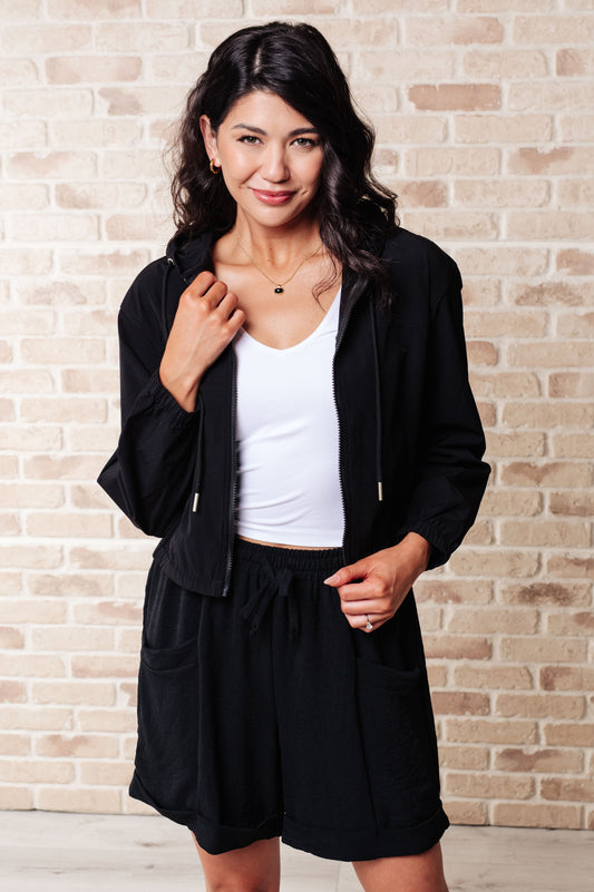 Plus size model wearing Sky Zip Up in Black featuring hood and front zipper.