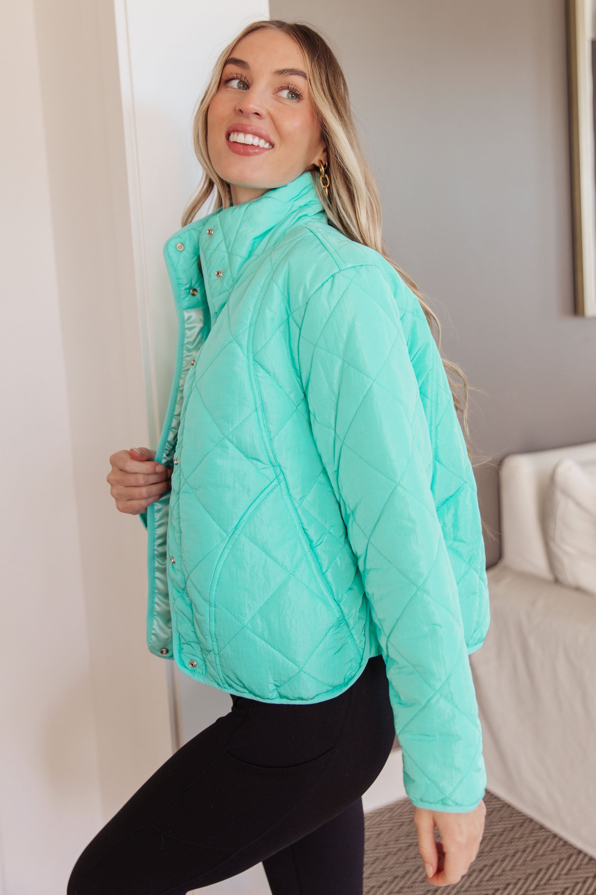 Side angle of Siyah Puffer Jacket highlighting turquoise color and sleek fit.