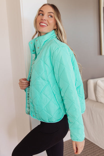 Side angle of Siyah Puffer Jacket highlighting turquoise color and sleek fit.