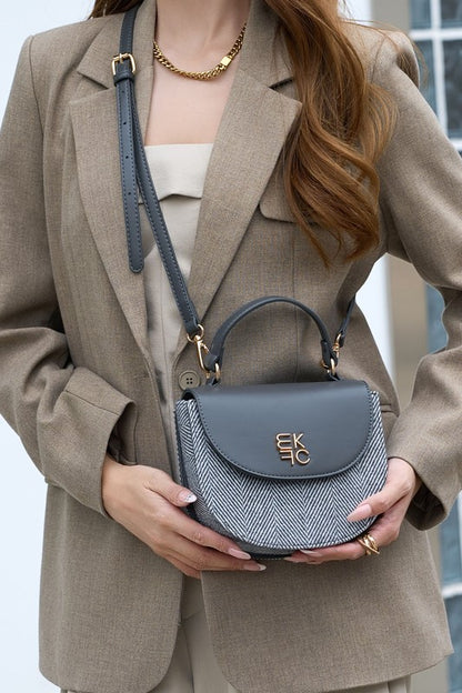 Woman wearing gray Heloise herringbone crossbody bag in crossbody style.