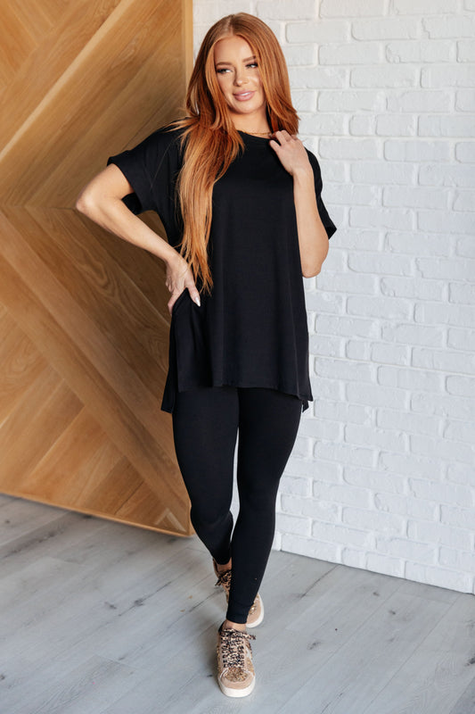 Women's black top and leggings set made with brushed microfiber. The top has a round neckline, dolman sleeves, and a high-low hemline with side slits. The leggings have a cased elastic waistline.