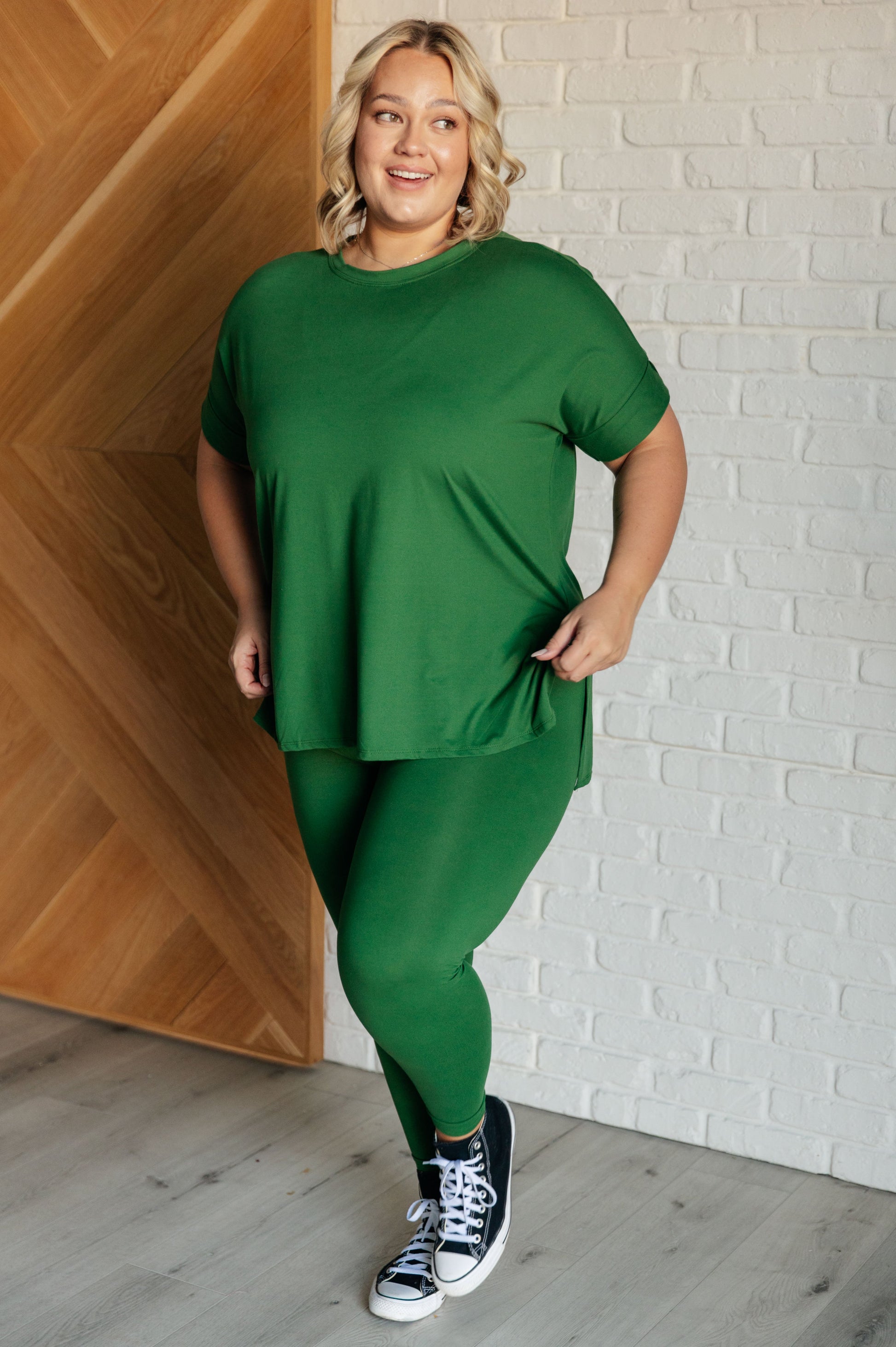 Women's dark green top and leggings set made with brushed microfiber. The top has a round neckline, dolman sleeves, and a high-low hemline with side slits. The leggings have a cased elastic waistline.