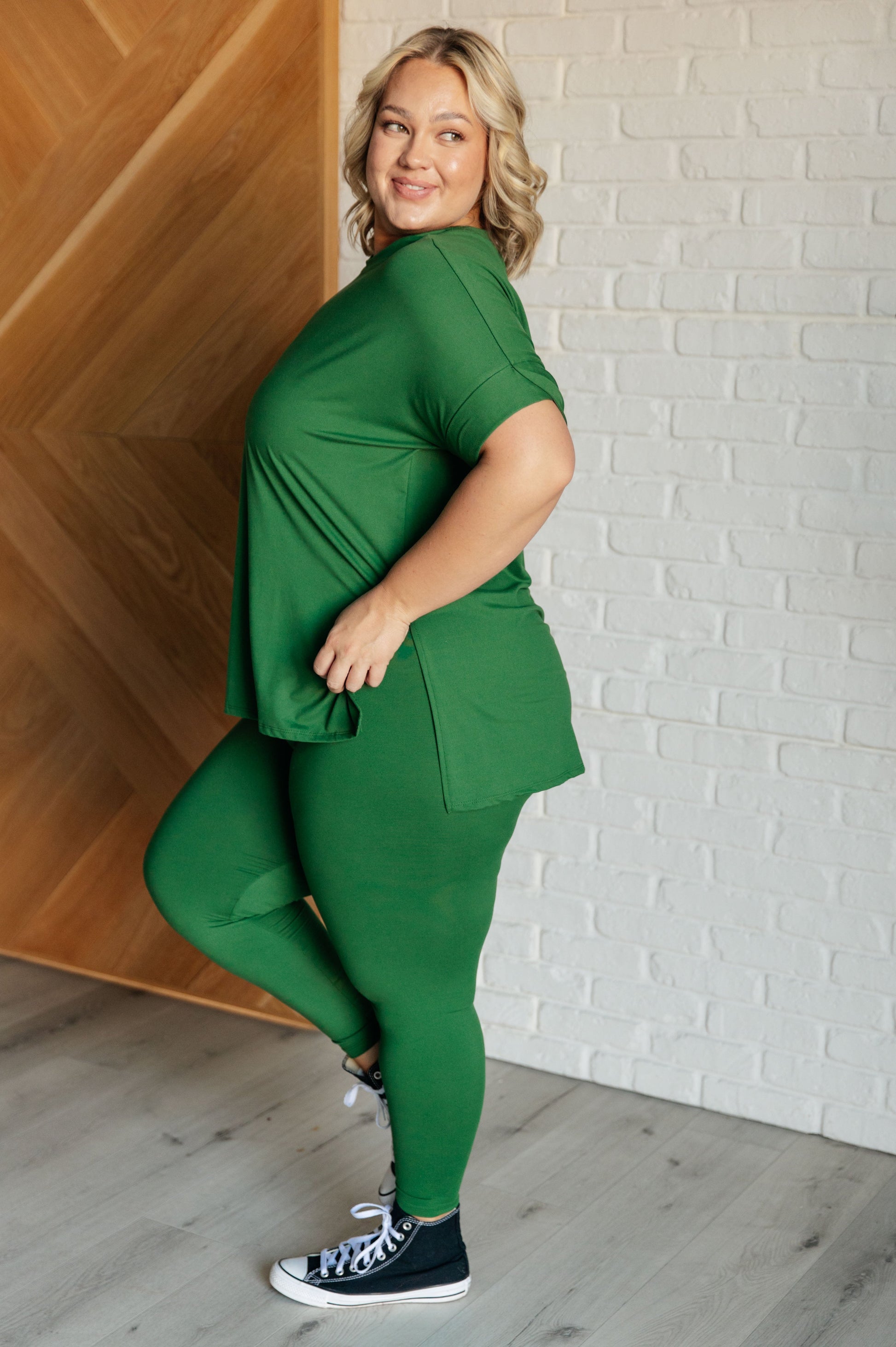 Women's dark green top and leggings set made with brushed microfiber. The top has a round neckline, dolman sleeves, and a high-low hemline with side slits. The leggings have a cased elastic waistline.