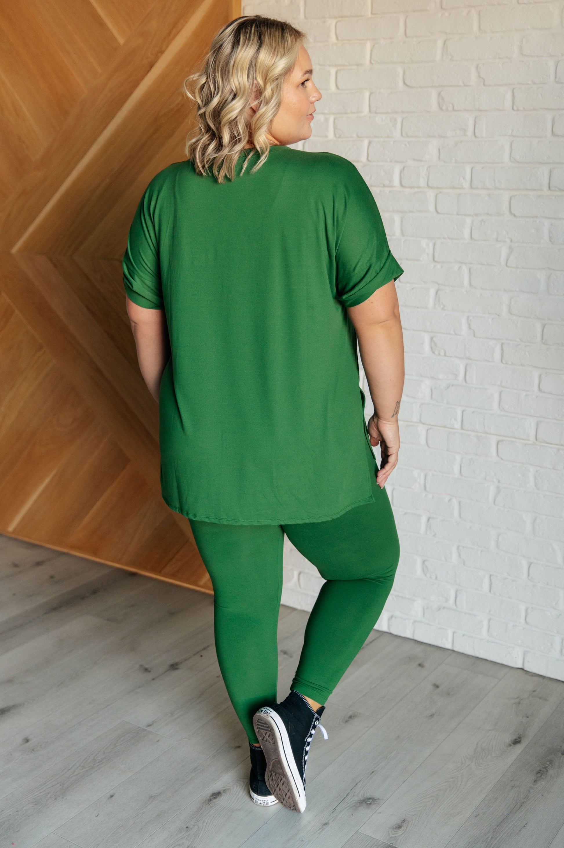 Women's dark green top and leggings set made with brushed microfiber. The top has a round neckline, dolman sleeves, and a high-low hemline with side slits. The leggings have a cased elastic waistline.