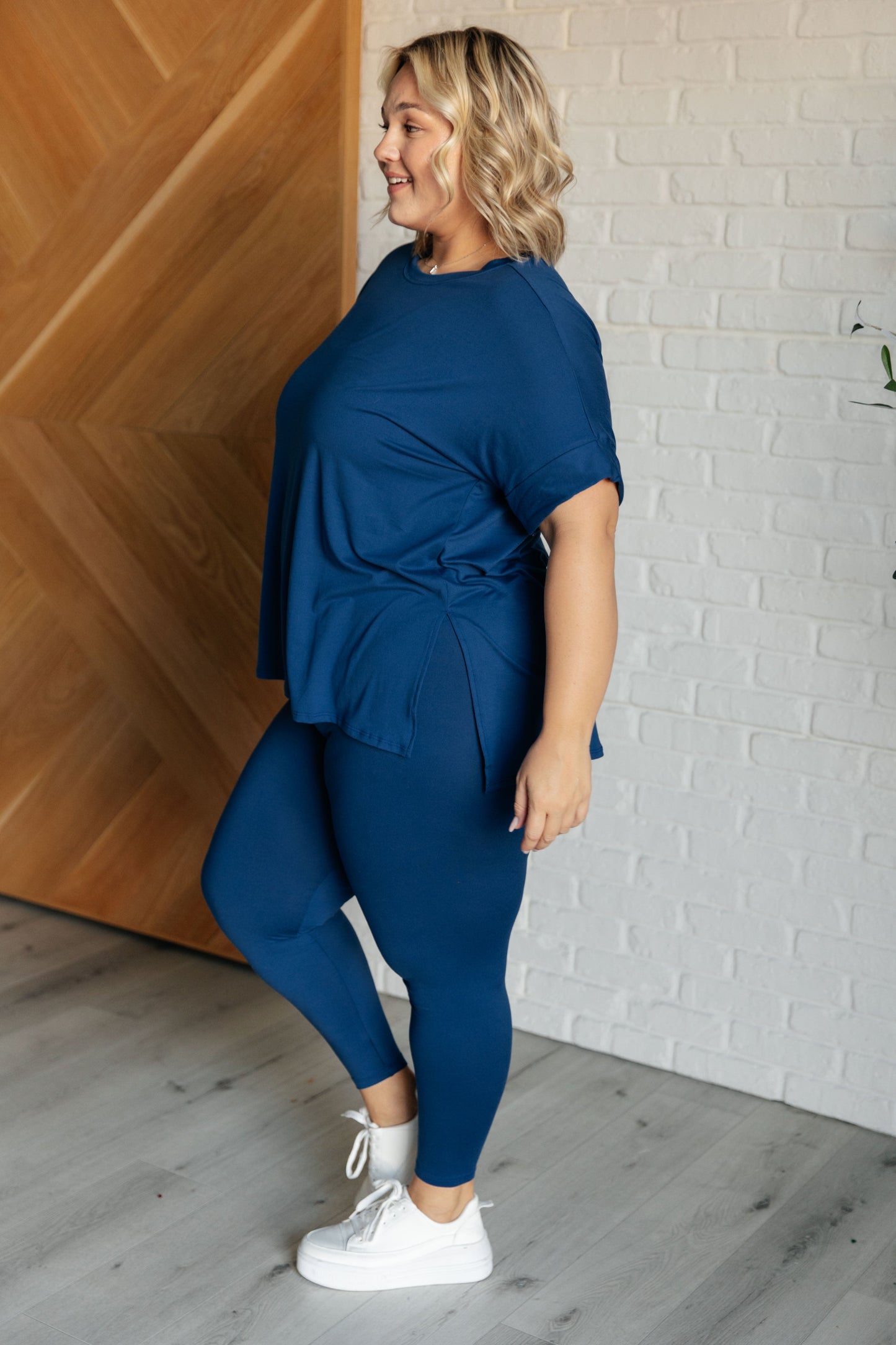 Women's light navy top and leggings set made with brushed microfiber. The top has a round neckline, dolman sleeves, and a high-low hemline with side slits. The leggings have a cased elastic waistline.