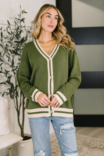 Model wearing Somara Full Front Button Down Cardigan in green with deep V-neck.
