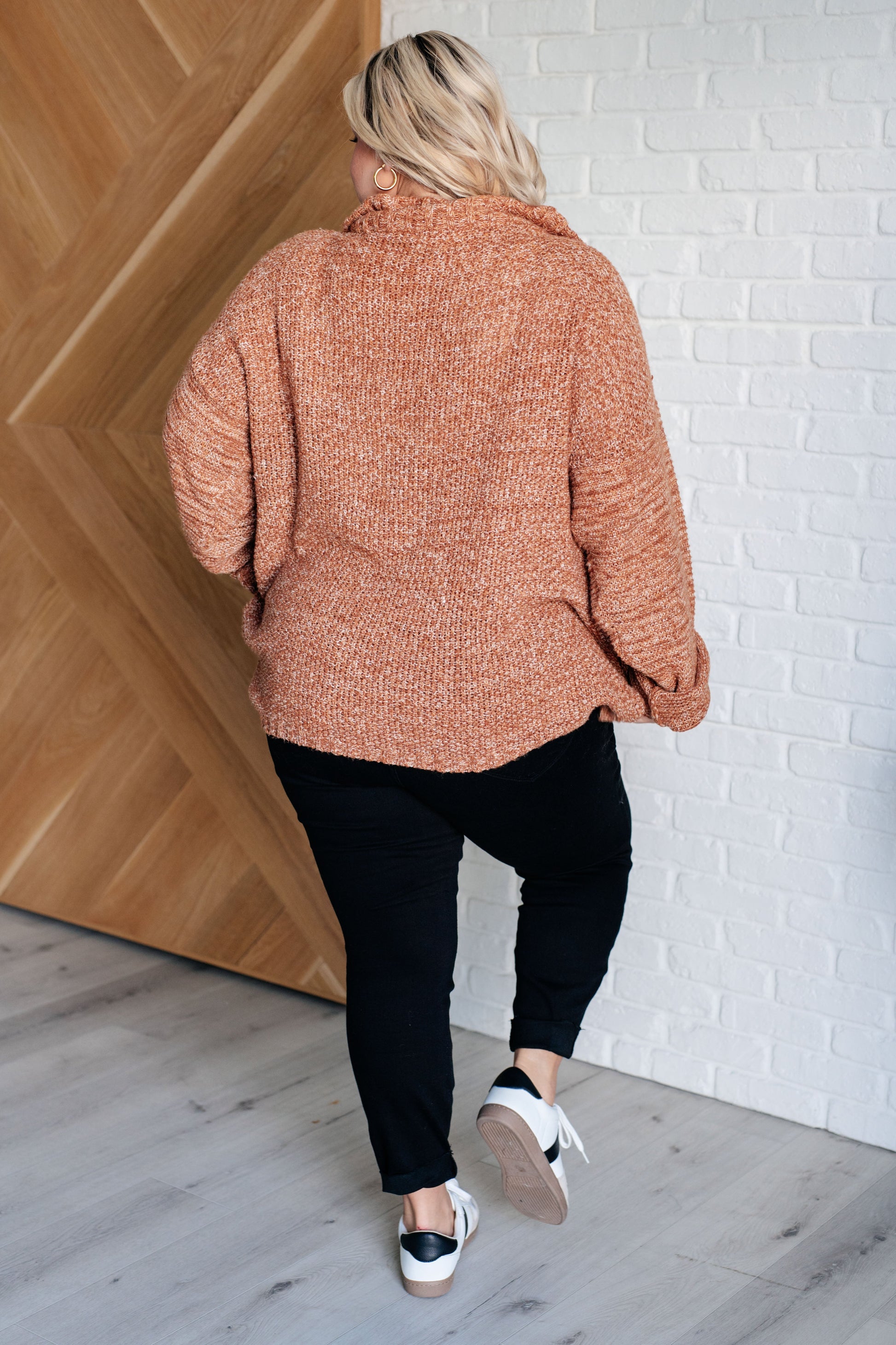 Women's oversized sweater with a mock neckline, half-zip closure, long sleeves, and drop shoulder design, made of sweater knit fabric.