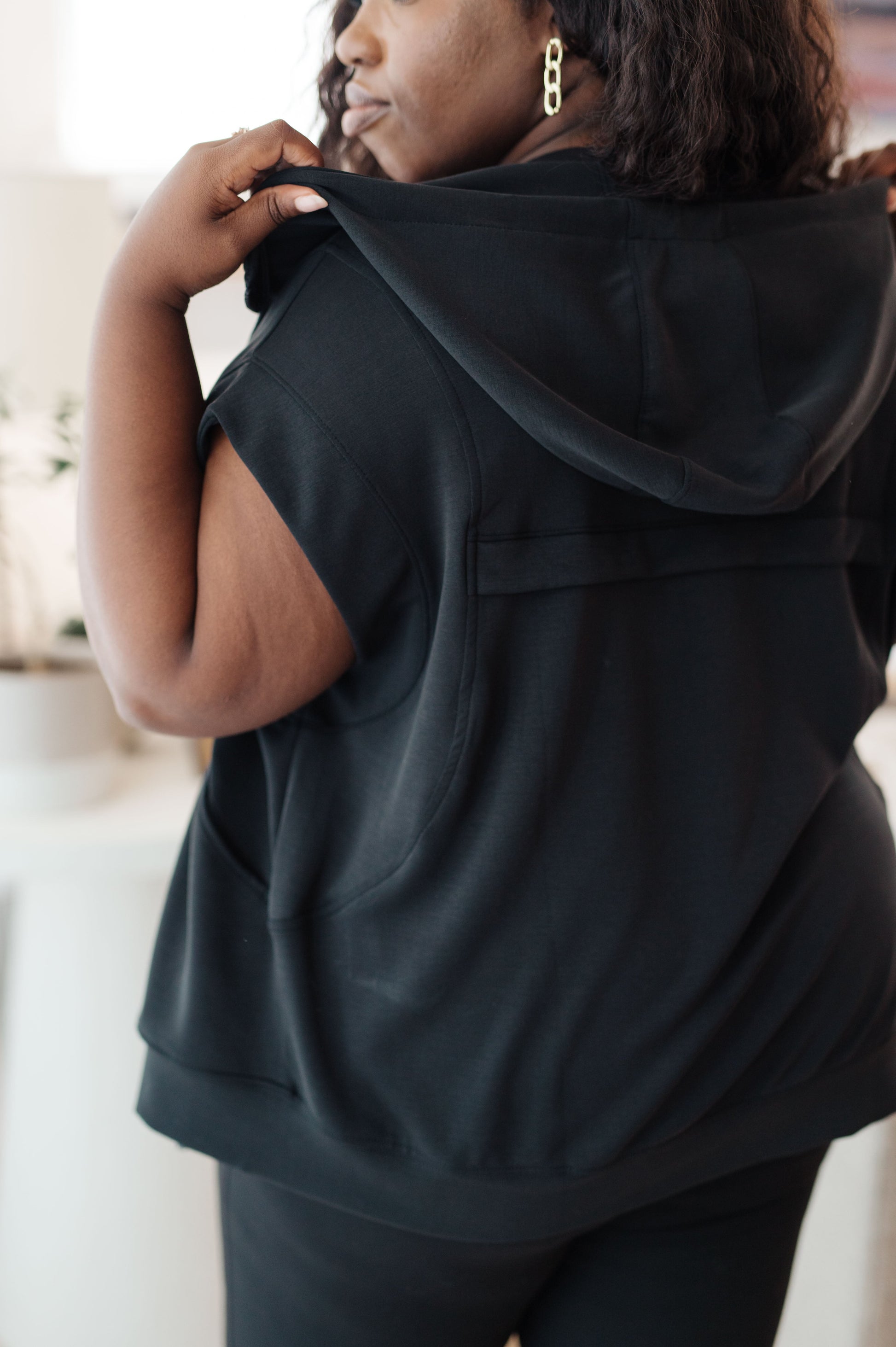 Back view of plus-sized model wearing the Isabella Sleeveless Hoodie, emphasizing the hood and relaxed silhouette.