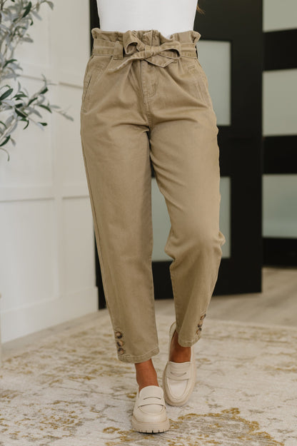 Model wearing Audie High Waist Trousers in beige with paperbag waist and detachable tie belt.