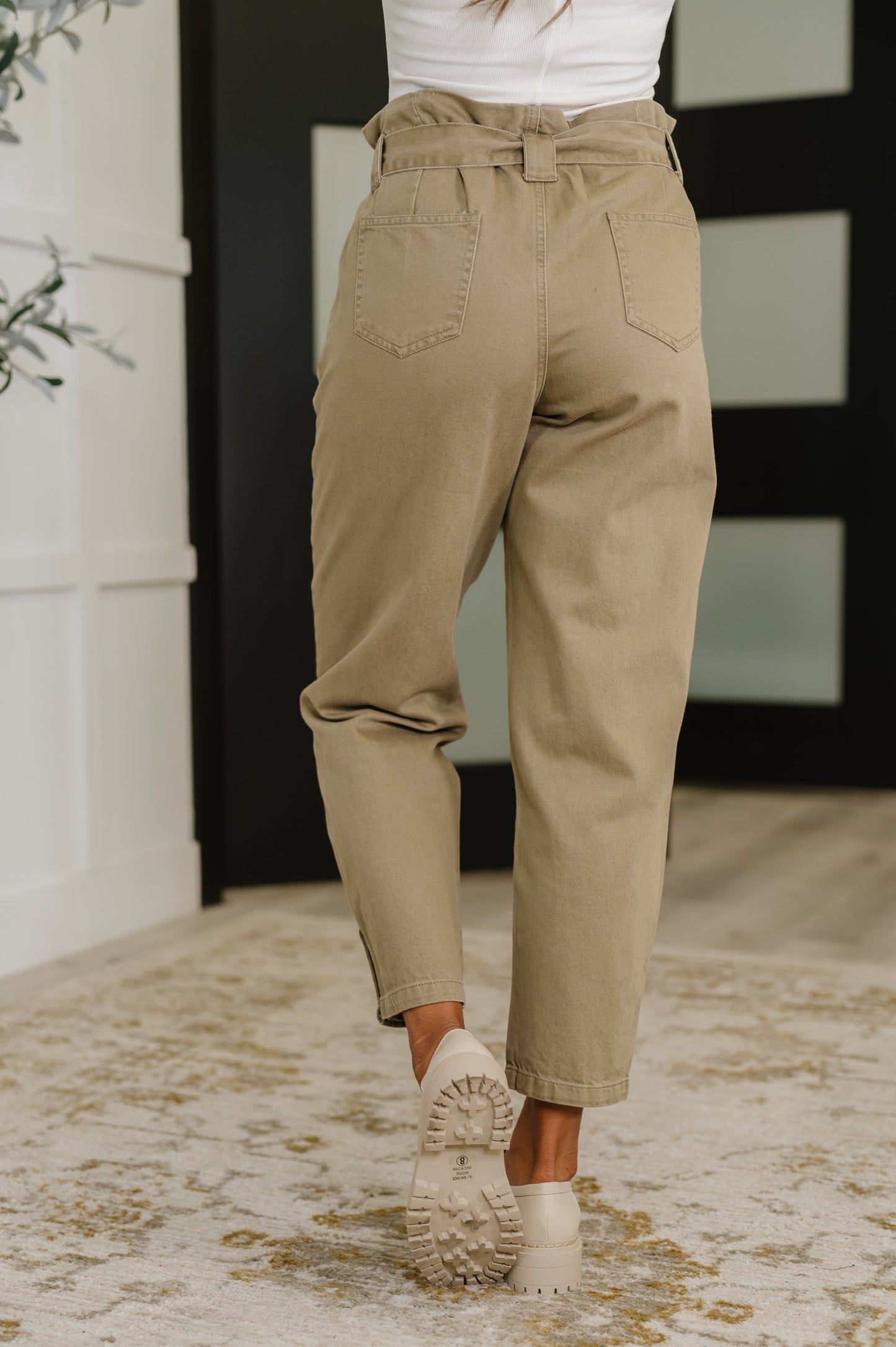 Model wearing Audie High Waist Trousers from the back, showing patch pockets and tailored fit.