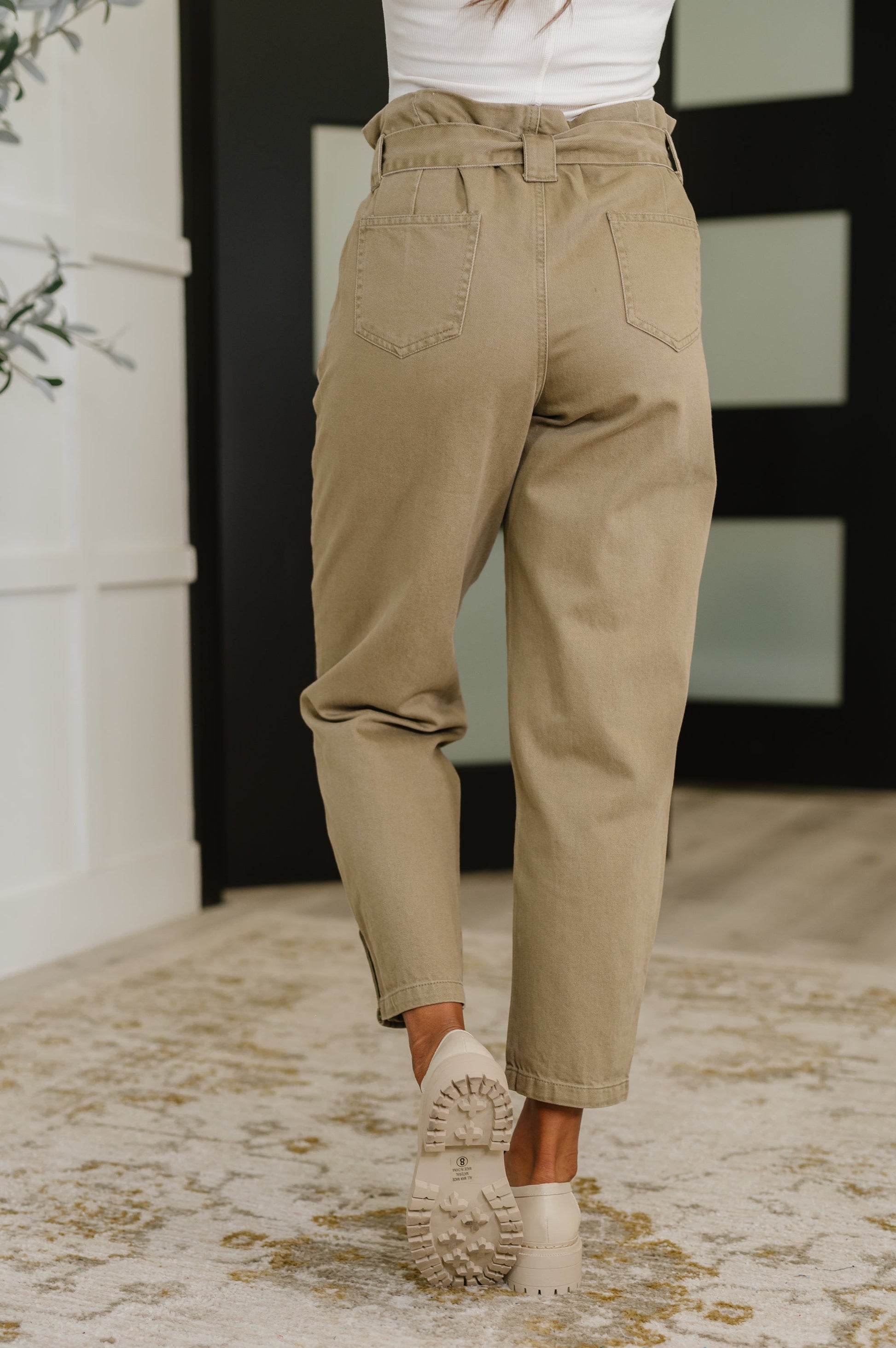 Model wearing Audie High Waist Trousers from the back, showing patch pockets and tailored fit.
