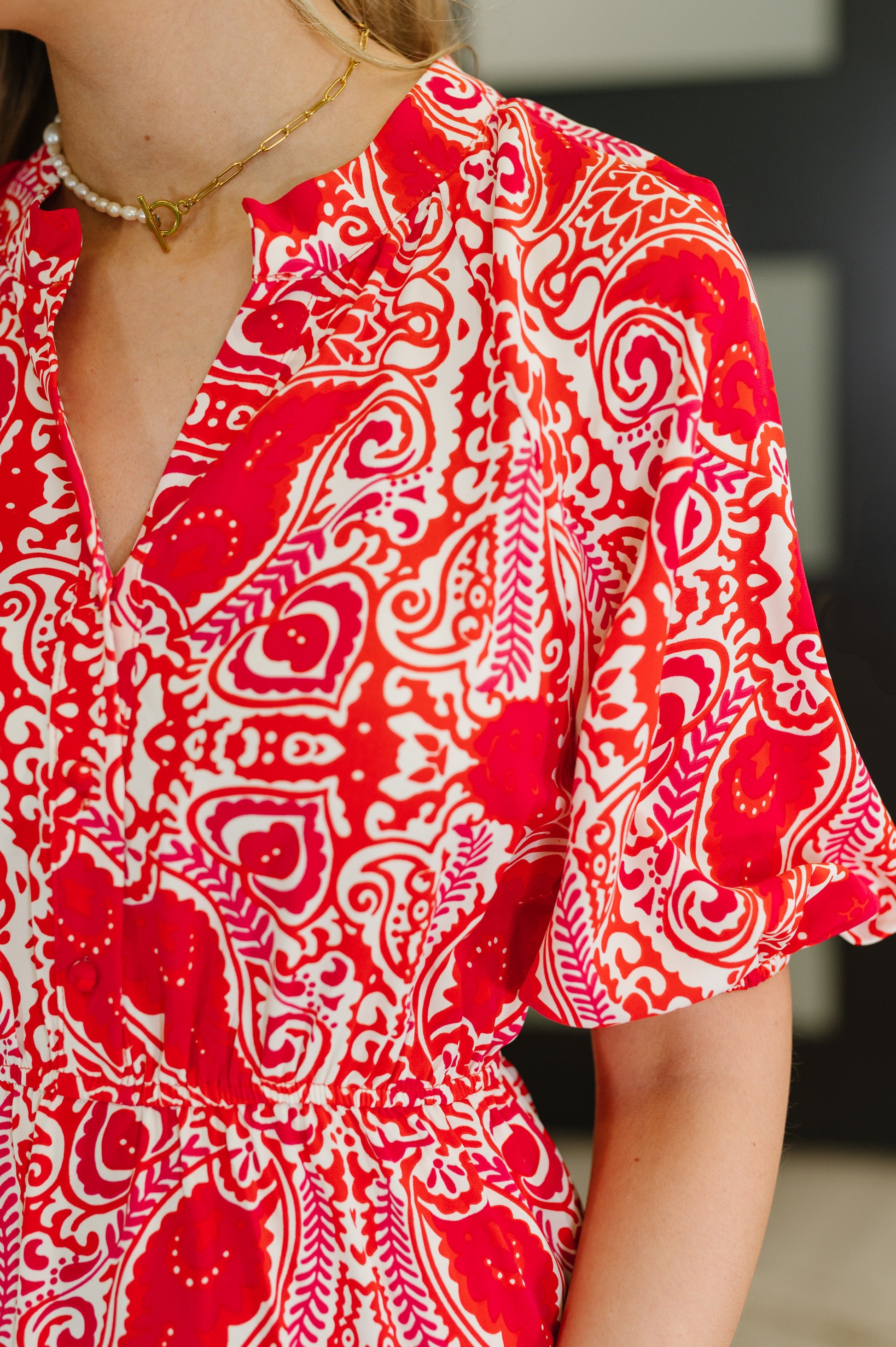 Close-up view of the Jemma Maxi Dress showcasing its unique red floral pattern and poplin woven texture.